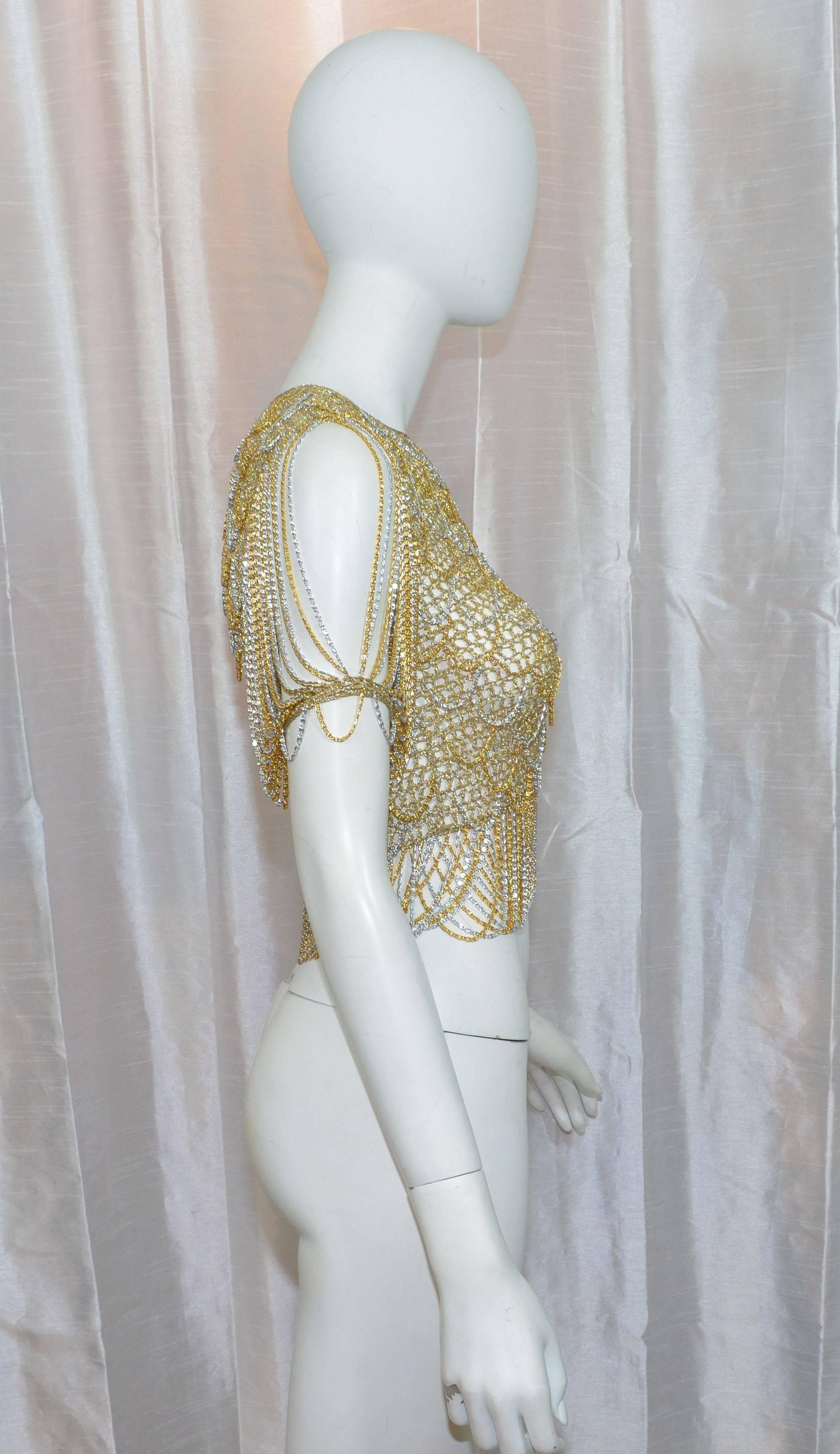 Loris Azzaro Top Metallic Gold and Silver Lurex Crochet with Chains

1970's metallic gold and silver crochet top with dangling chain detail, chain sleeves, and a faux pearl button closure on the back of the neck. Loris Azzaro was a French designer