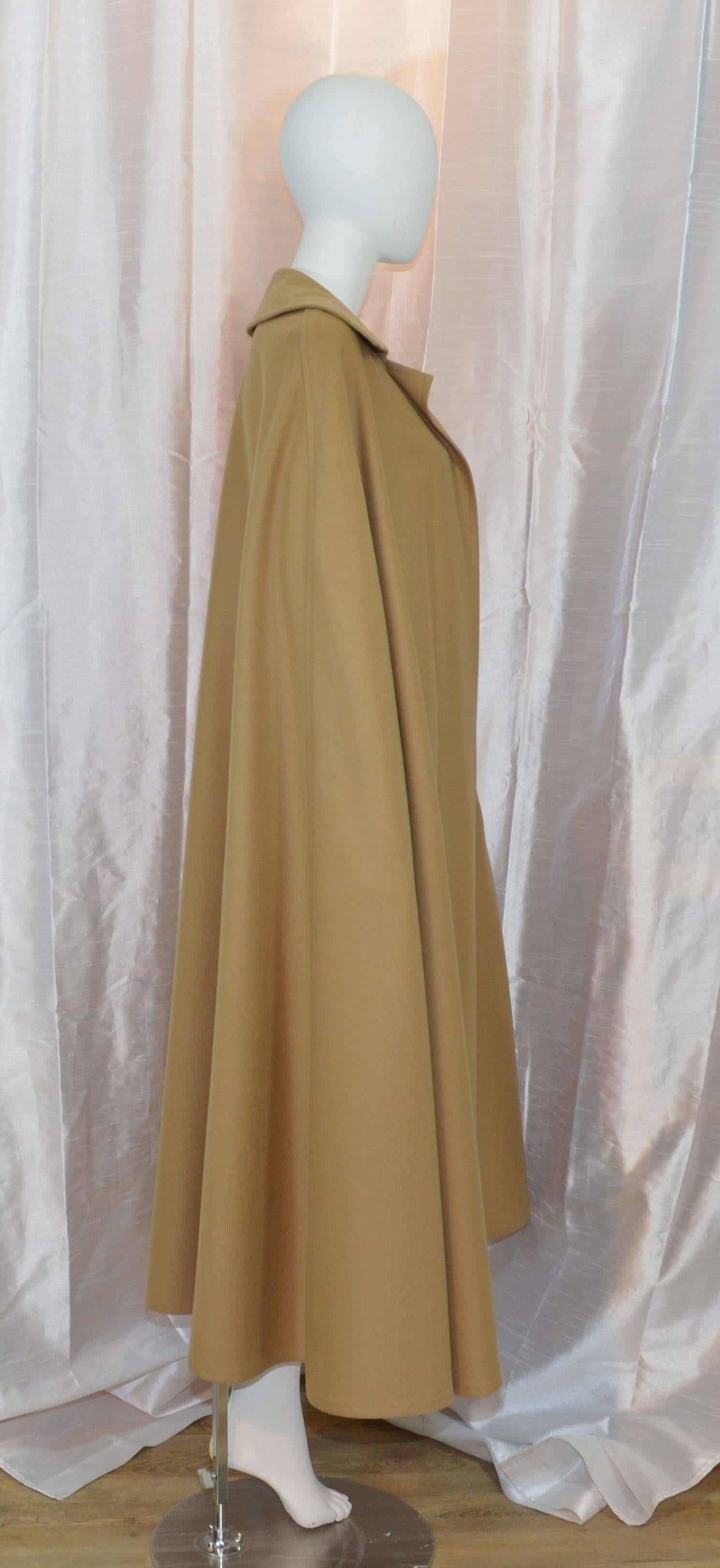 Iconic Vintage Yves Saint Laurent 1970s cape featured in camel color, made of 100% wool, unlined, labeled size 42, and made in France. Length measures: 51''