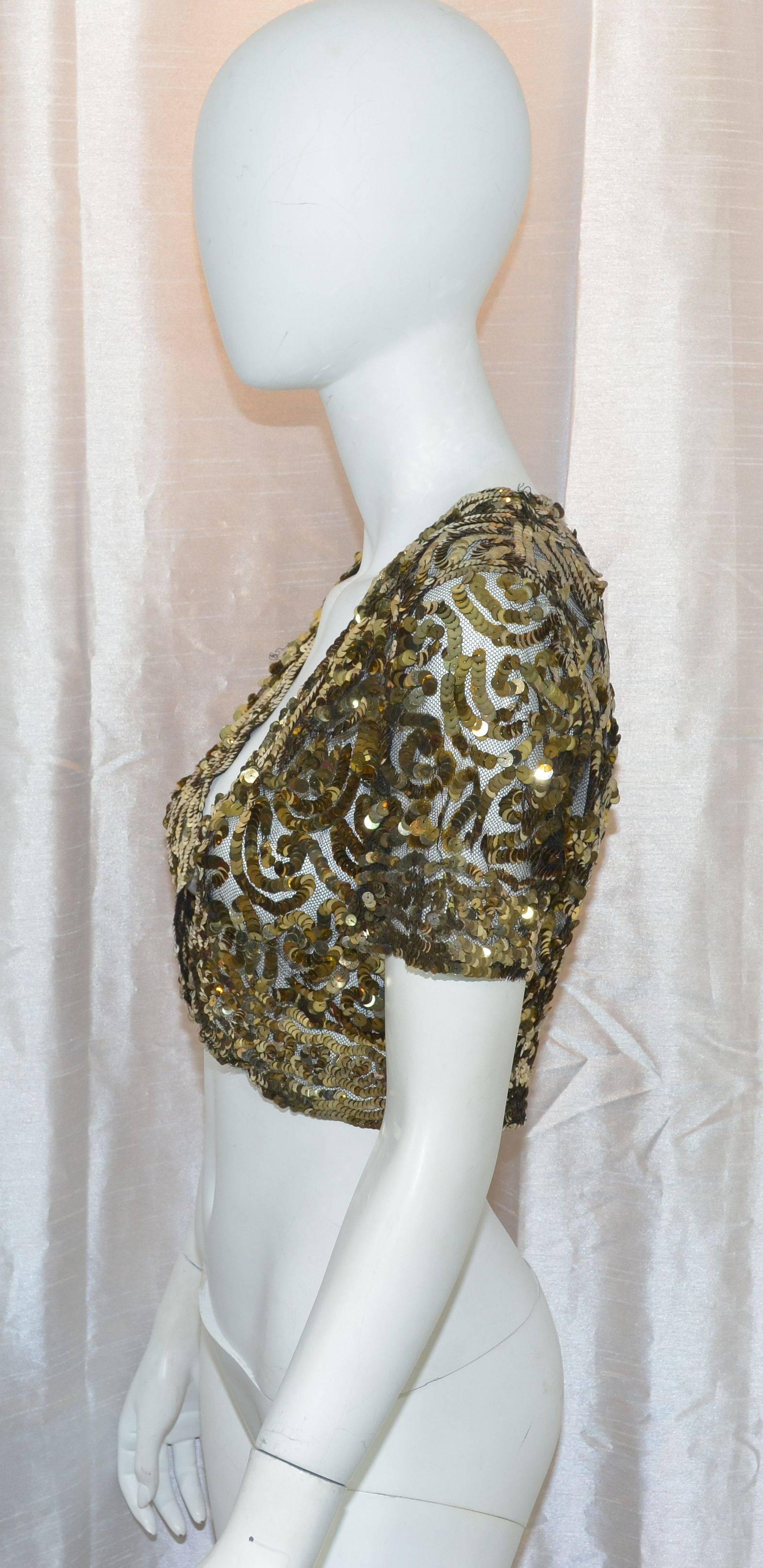 Vintage bolero from the 1930's featured in gold cellulose sequins on a black tulle netting fabric. Excellent condition. 
Measurements: bust-35'', shoulder to shoulder-14.5'', length-15''