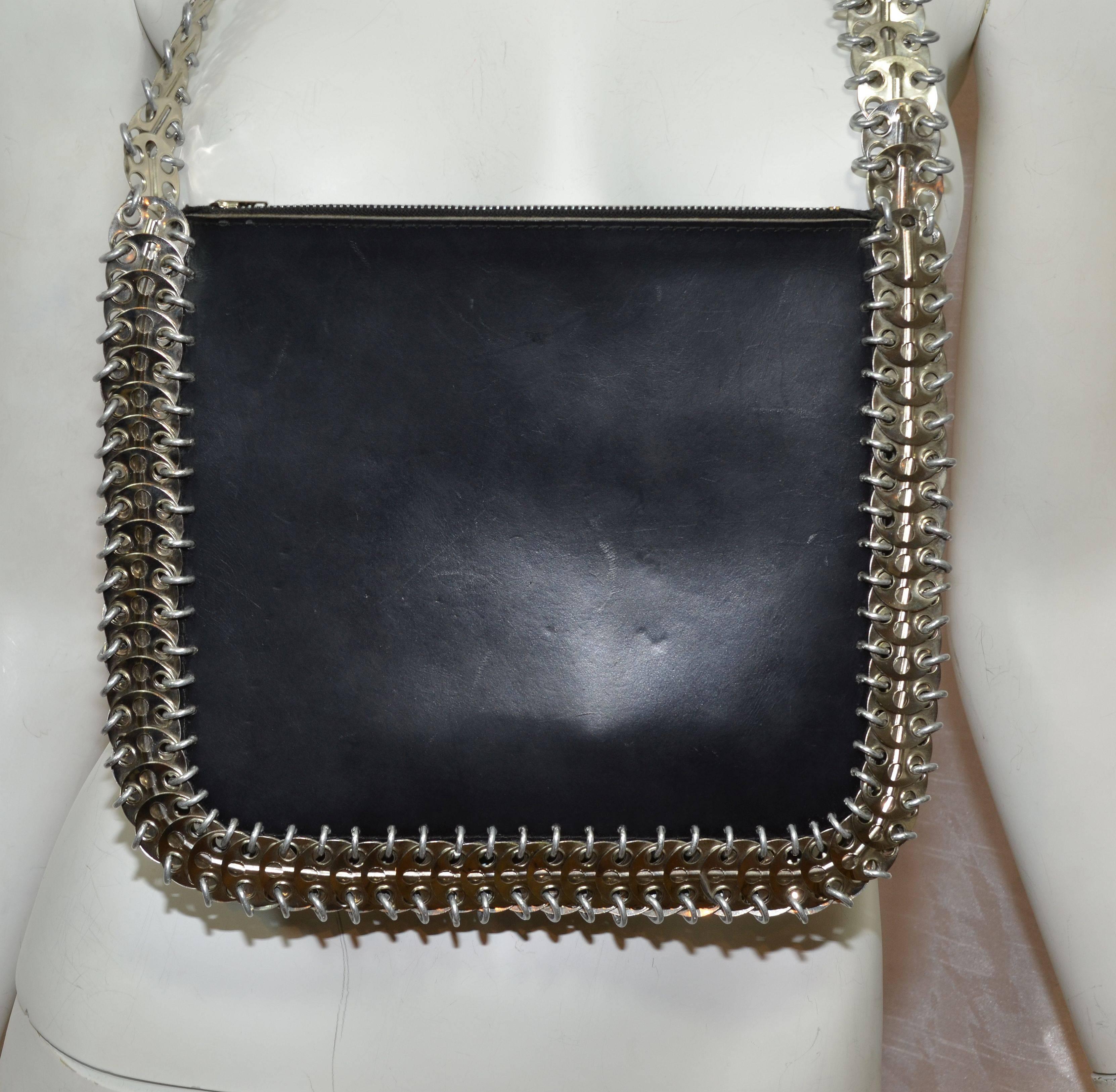 Paco Rabanne shoulder bag in black leather and metal disks. The disks are attached with aluminum links. There are two zippered pockets and an open center compartment. Bag in in excellent condition with minor wears to the leather. Measurements are: