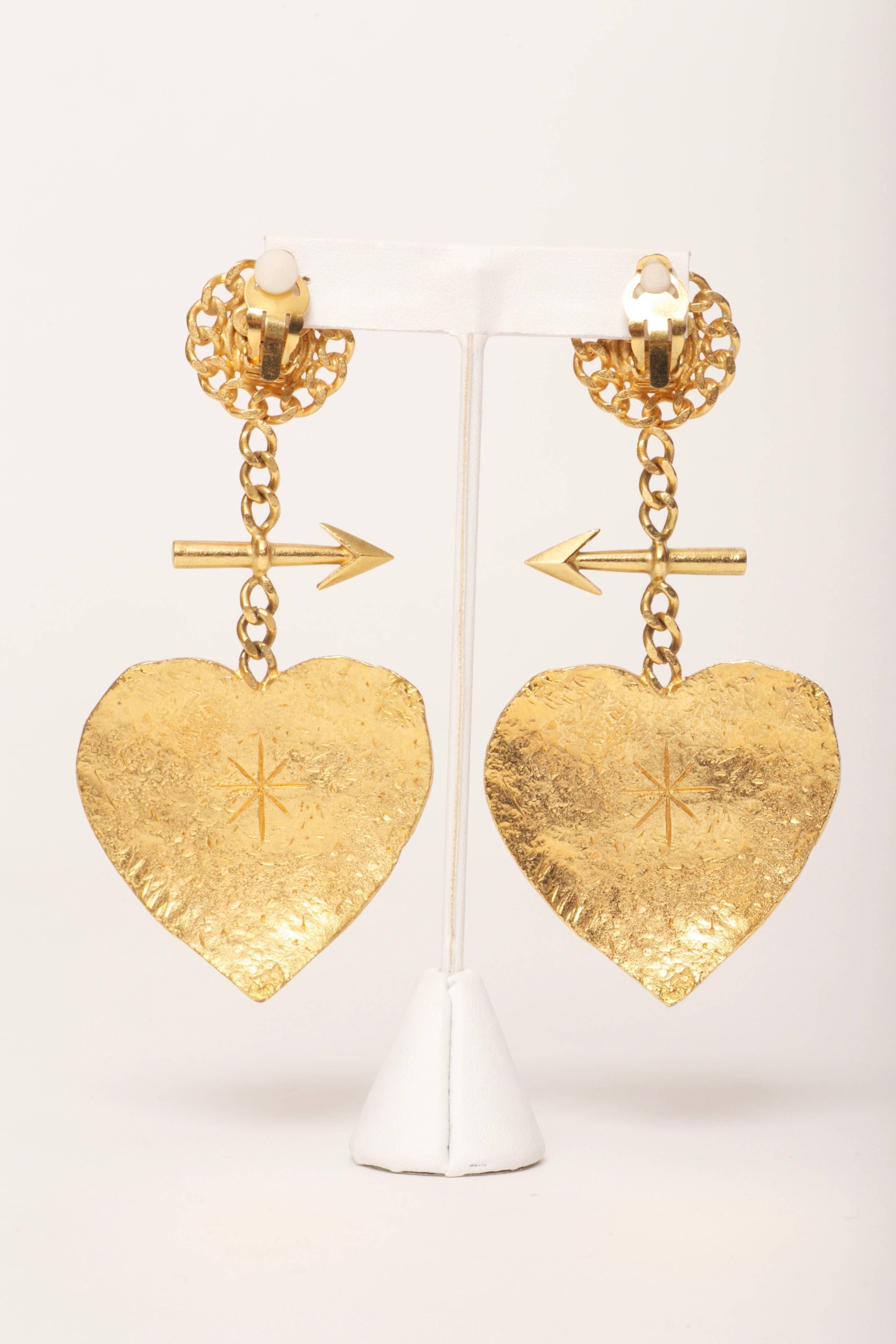 XXL Chanel, Cambon, Paris Graffiti Heart & Arrow Earrings Vintage 1993

Rare Heart and Arrow gold tone textured metal Chanel clip on earrings. Chain around button top and chain drop with arrow. Large heart drop that has Chanel, Cambon Paris