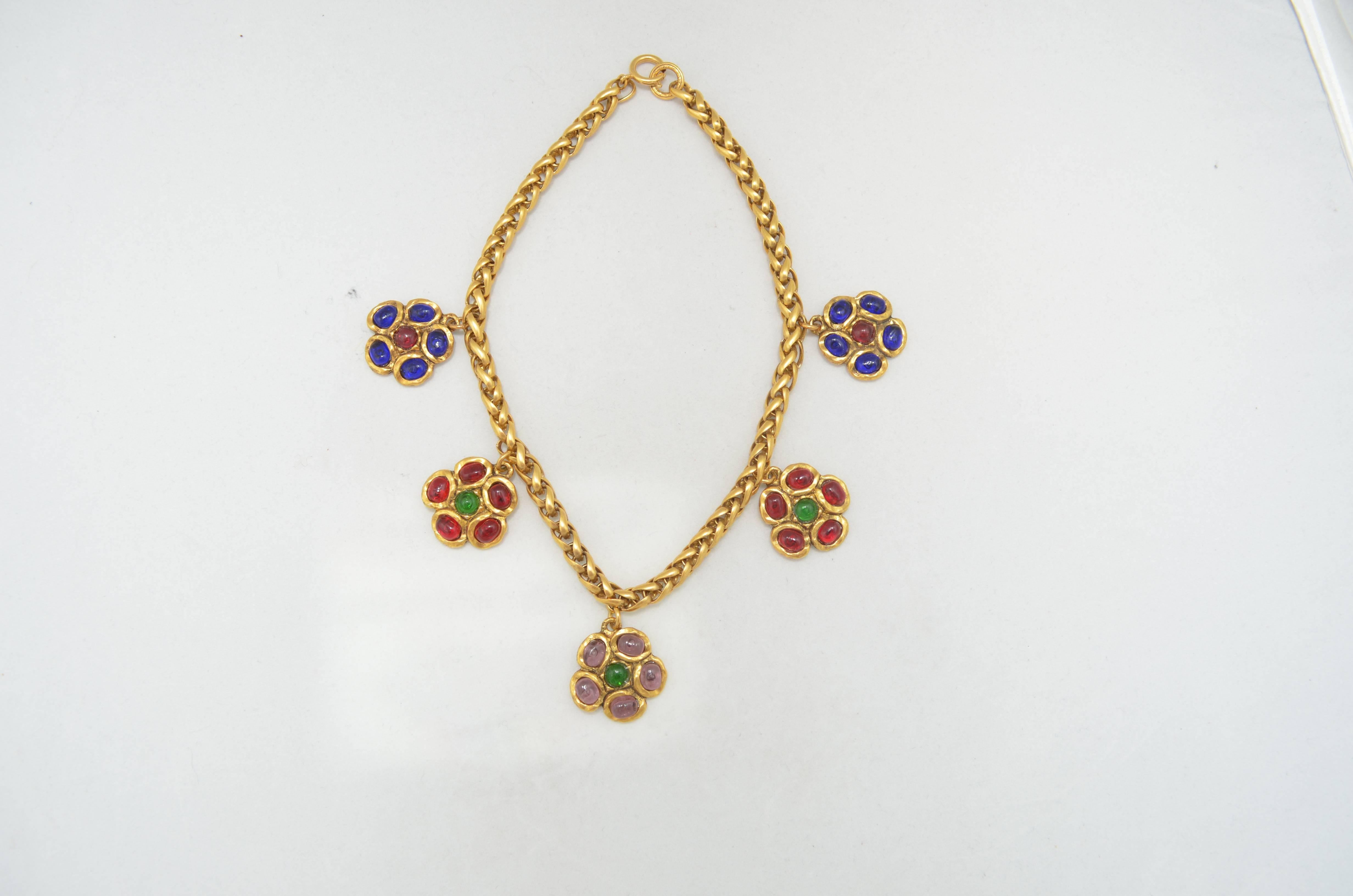 Chanel 1981 Gripoix Flower Necklace with goldstone woven rope chain, and 5 flower drops featuring lavender and green center flower, red and green flowers and blue and red flowers. Circular Chanel id plate on the back of center flower reads Chanel