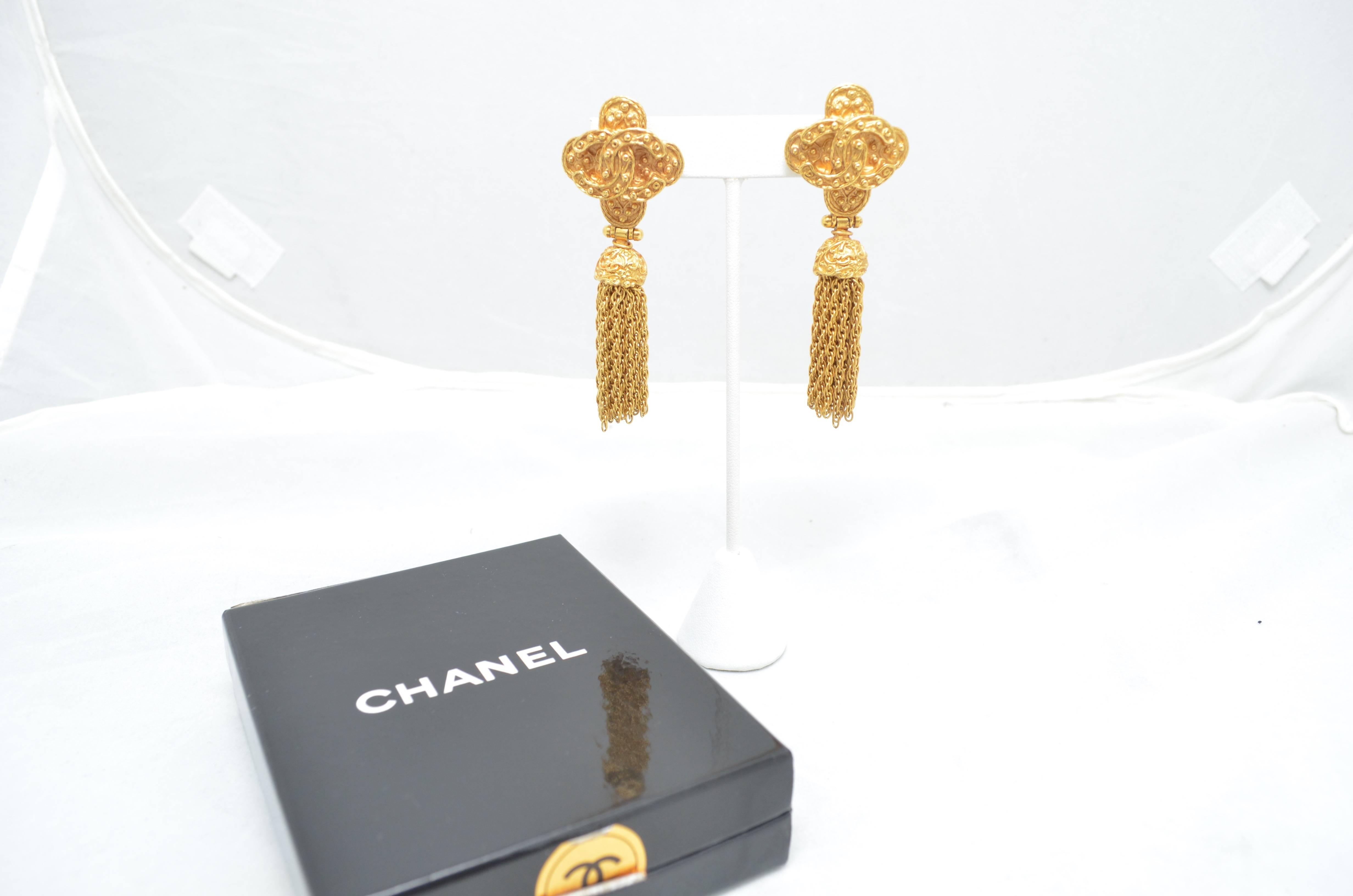 Vintage Channel tassel earrings with clip-on backs.  Gold tone metal. Chanel plaque stamped: Chanel 94A, Made in France. Excellent condition.

Measurements in inches:
Height: 3
Clip On Width: 1 1/8 