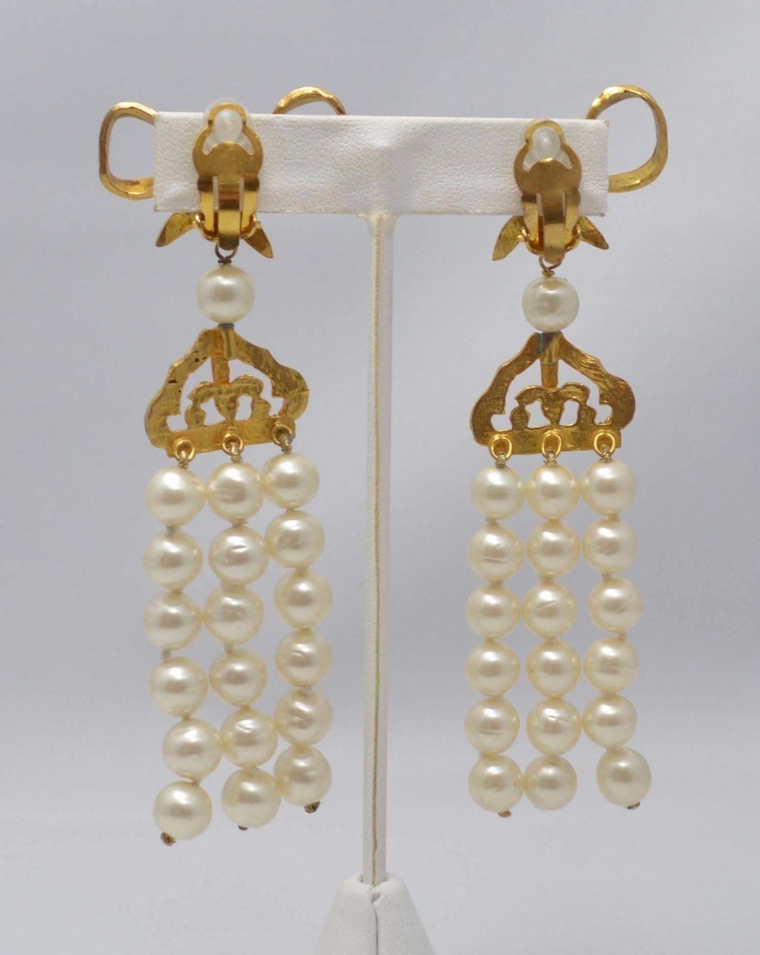 Chanel three strand faux pearl drop/chandelier clip earrings with low top. Chanel signature plate on the back of each earring behind the clip is the round plate signifying that these earrings are from the 1970's or very early 1980's. Excellent