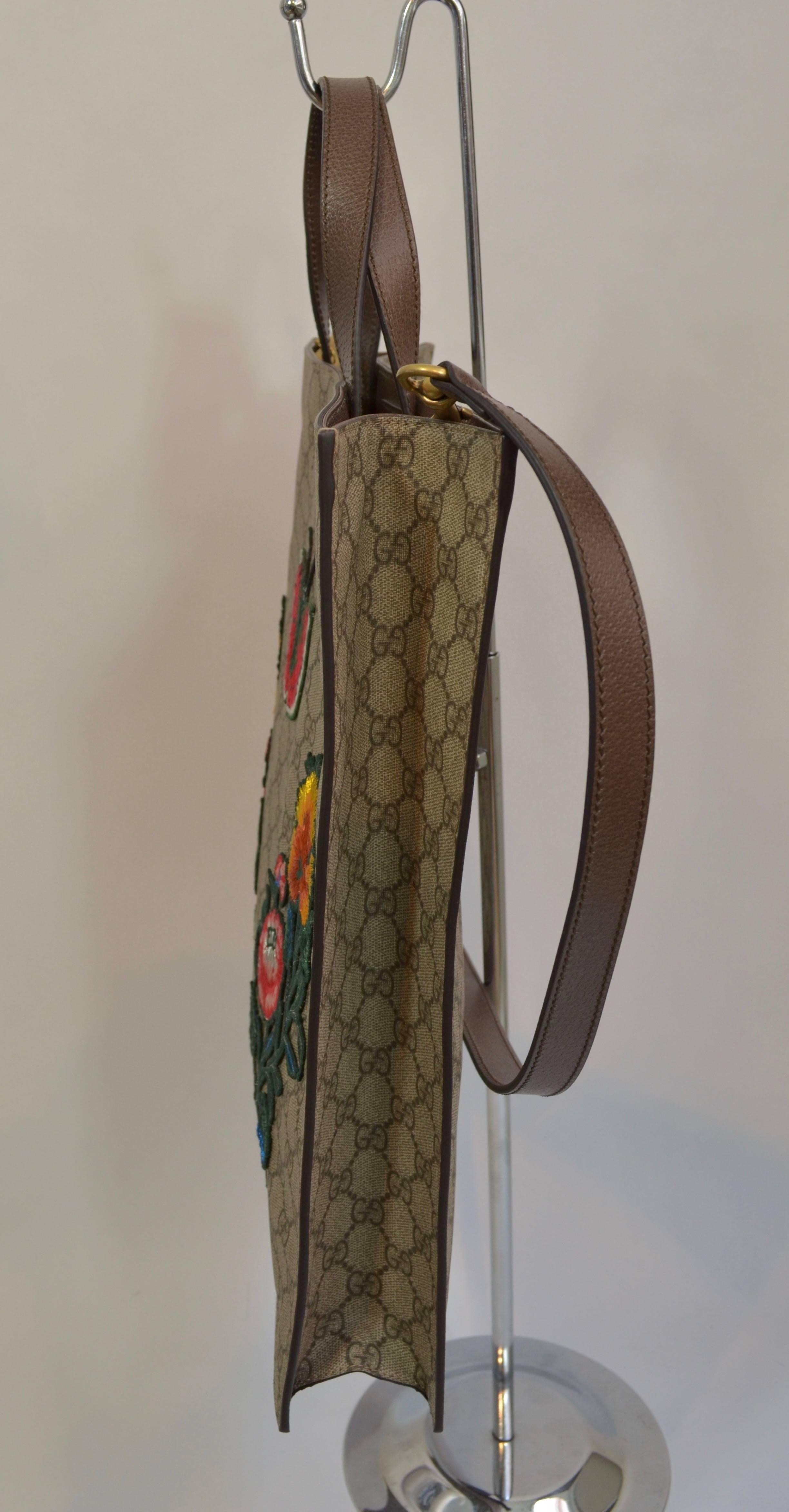 New with Tags still attached and unused Gucci Supreme Embroidered Butterfly 
Coated brown GG logo monogram canvas detailed with colorful embroidered flowers and a butterfly. Carry it by the two top handles or the adjustable crossbody strap. The