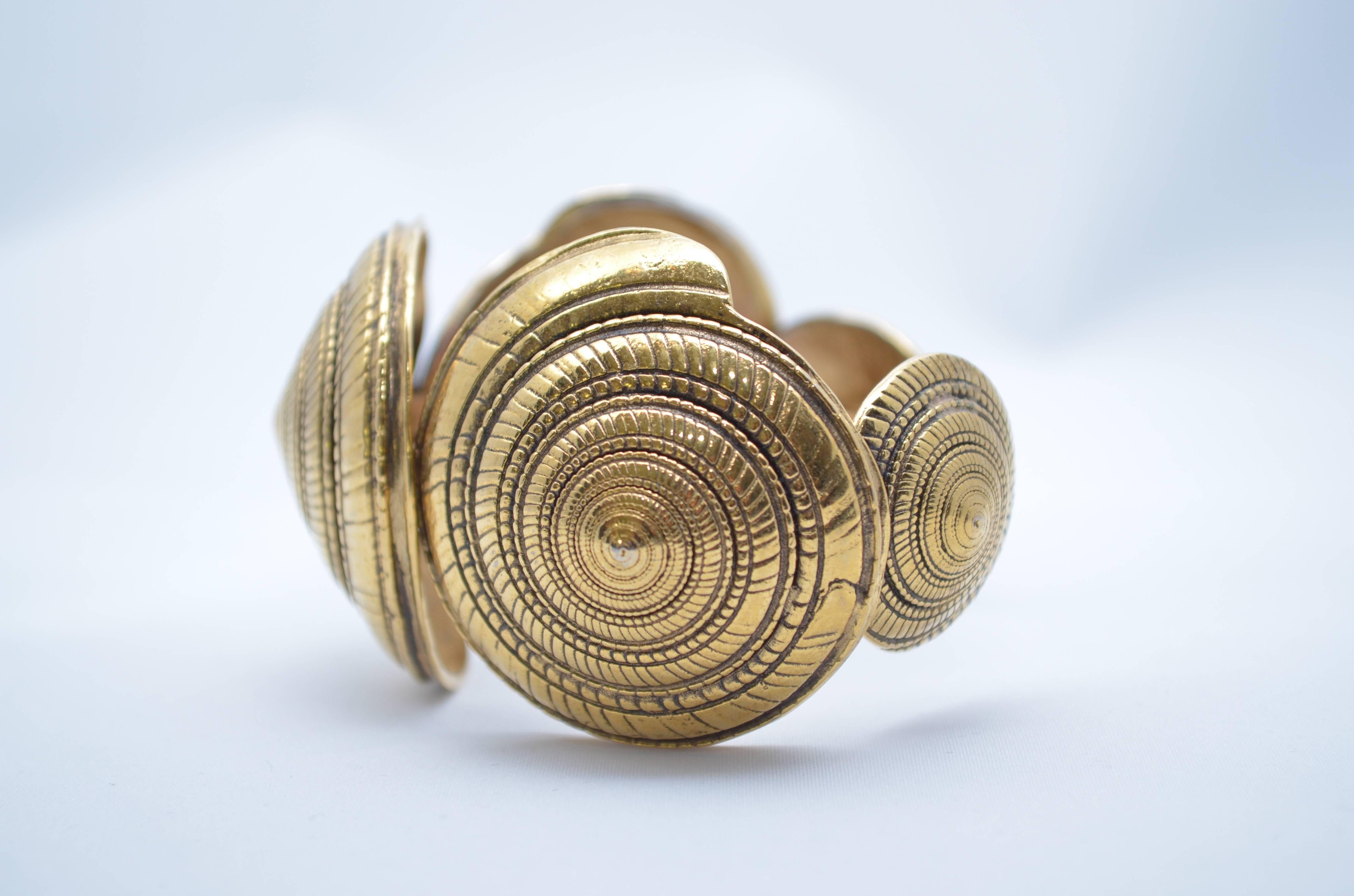 Yves Saint Laurent Rive Gauche 1970s Nautilus Shell Cuff

Gold base metal cuff made of five graduated metal etched nautilus shells with antique patina. Marked Yves Saint Laurent Rive Gauche Made in France. Excellent Condition. 