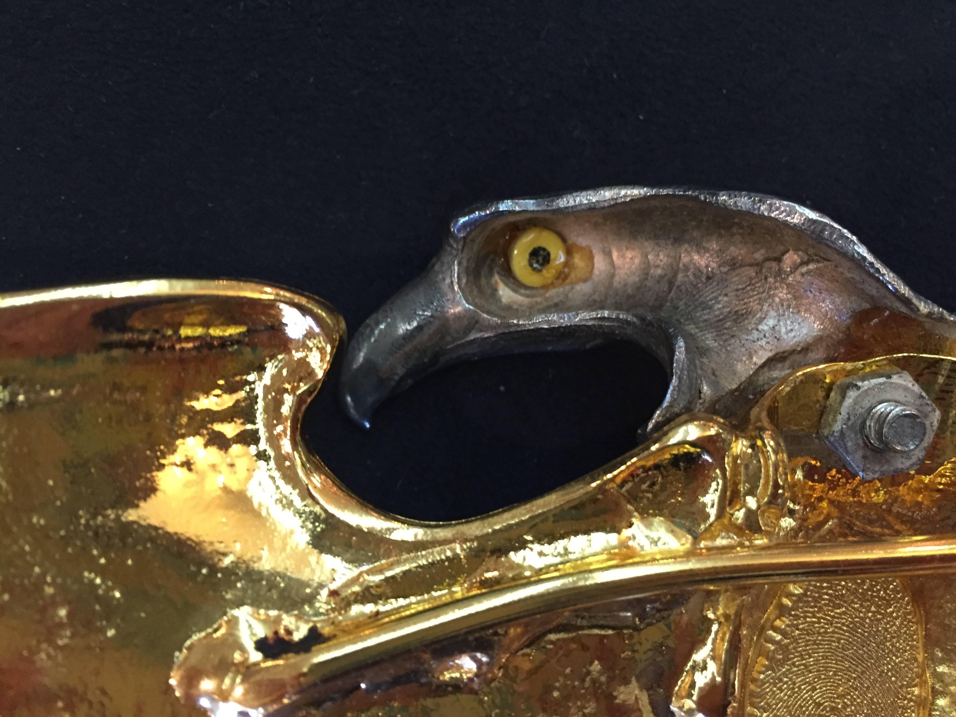 Exquisitely crafted vintage Christopher Ross American Bald Eagle belt buckle sculpture. Sculpture is 24K gold plated with a silver head, this striking statement piece is adorned with a glass eye and unique fingerprint marking. This piece is signed