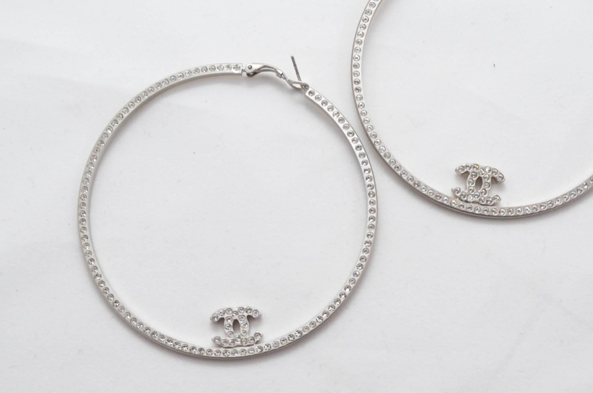 Beautiful extra-large light silver tone metal Chanel crystal Boucles Oreille hoop earrings. From the 2008 spring Collection. Made in Italy. For pierced ears. Features signature CC markings on each hoop. 

Measurements in inches:
Circumference 3
CC's