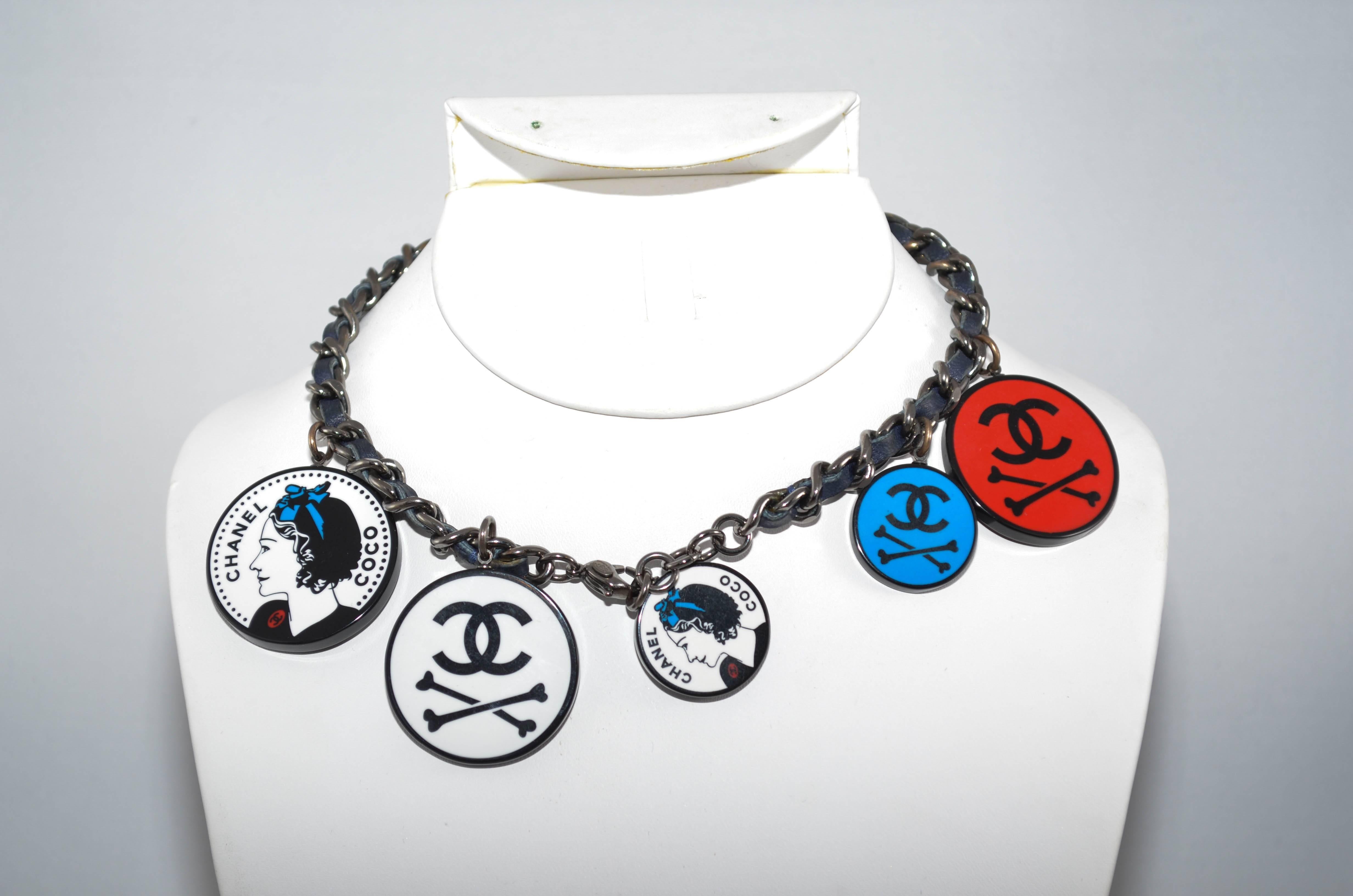 Coco Chanel black leather chain necklace featuring distinct Coco Chanel pendants 
with trademark CC. Cross bone pendants in red and black, white and black, and blue and black. Pendants in two different sizes; small 1