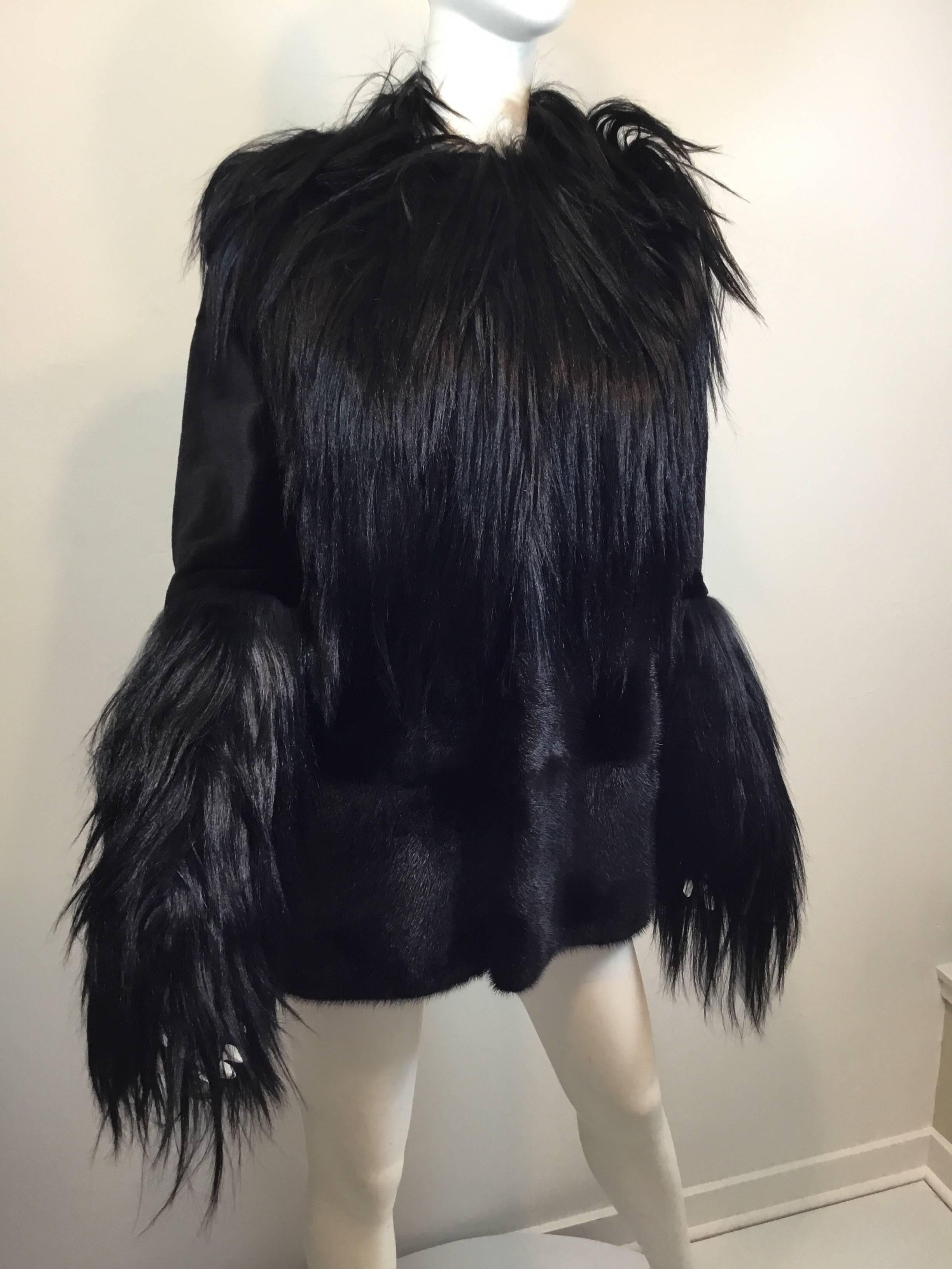 Black Michael Kors car length fur coat in Long goat fur with sheared mink upper sleeves and mink on the lower bodice. Lined in satin with velvet lined slash pockets at the hips. Four covered hook closures down the front. Approximate size 8.