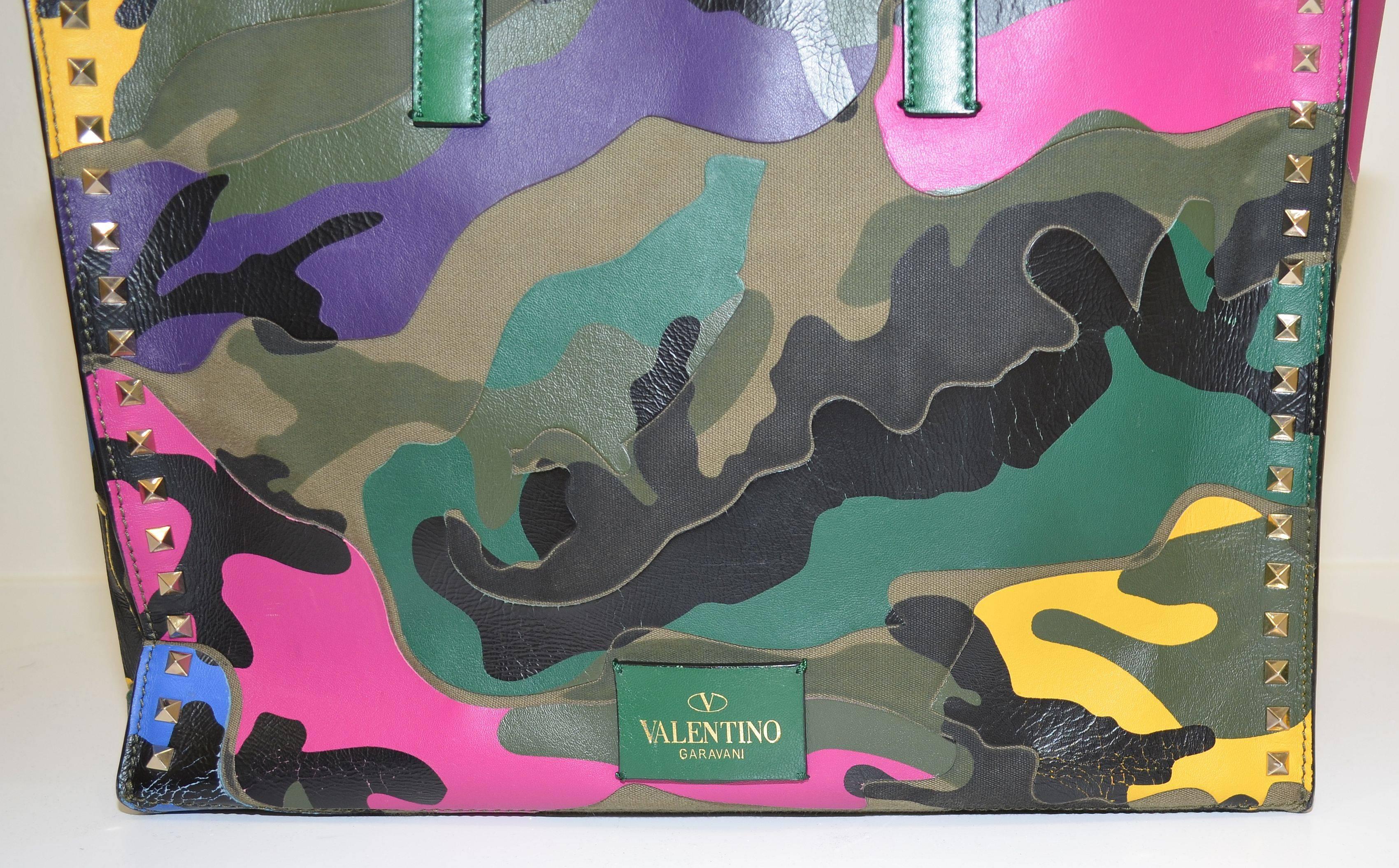 Valentino camo tote featured in an olive green and multicolored camouflage patchwork pattern throughout, canvas and leather with gold-tone signature rock stud studded detail. Flat leather top handles, spacious interior fully lined in leather, 3