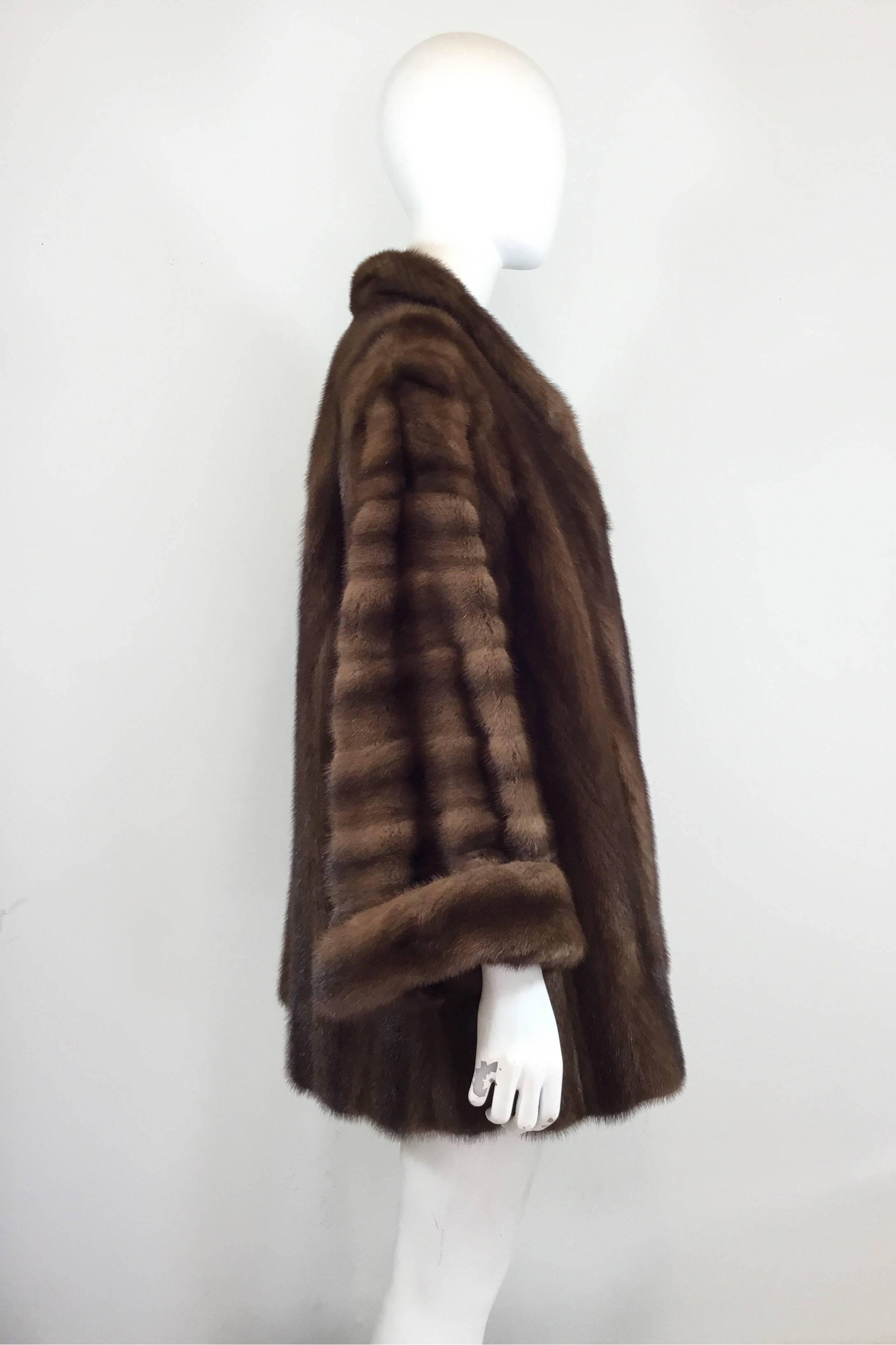 Christian Dior coat featured in brown mink fur with a single button closure. Coat is fully lined and has pockets at the hem.

bust 40'', sleeves 20'', length 33''