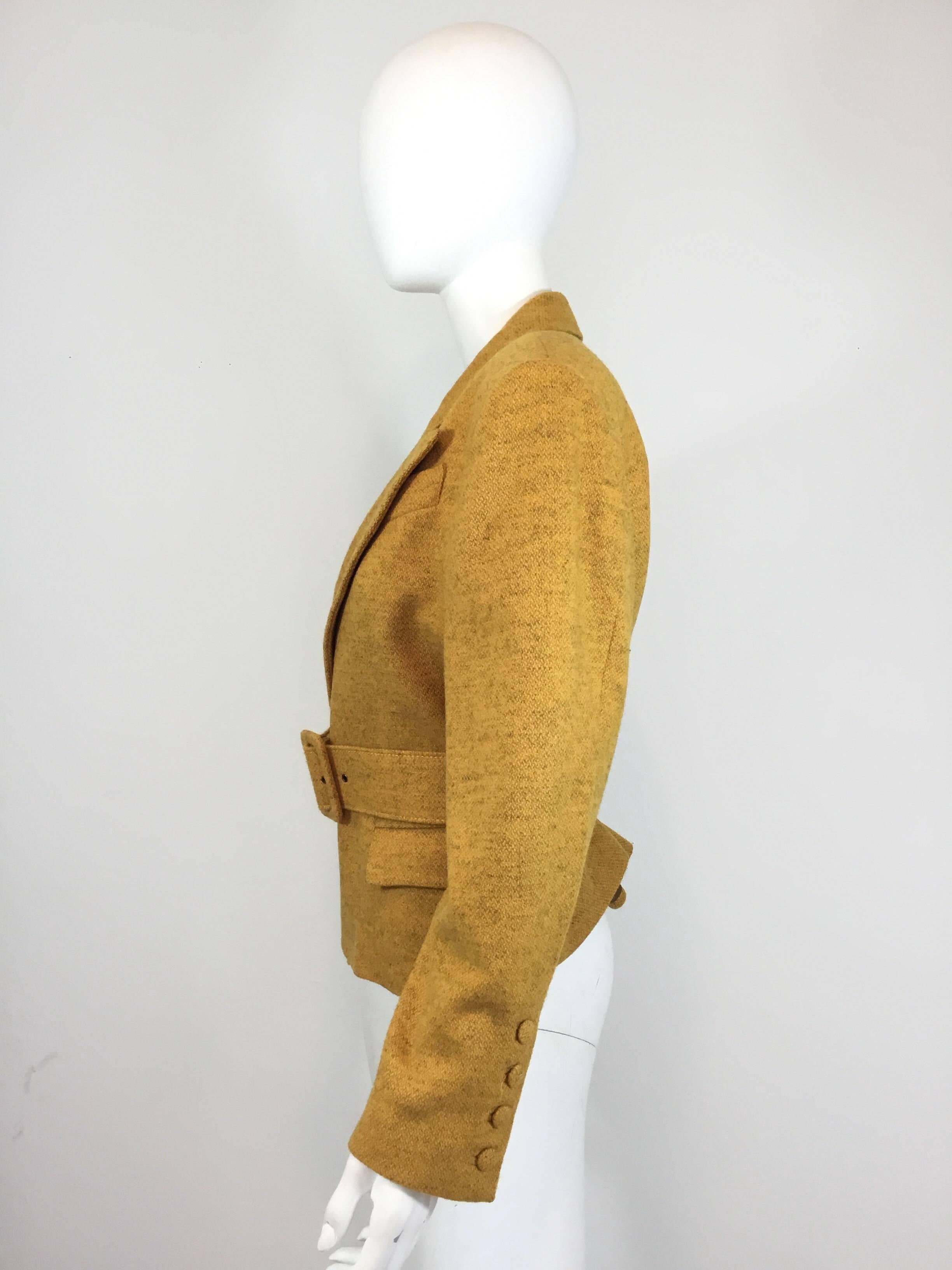 Jean Paul Gaultier wool mustard yellow jacket features a belted closure and two flap pockets at the hem. Jacket is fully lined, made in Italy, size 42.

Bust 40'', sleeves 23'', length 24''