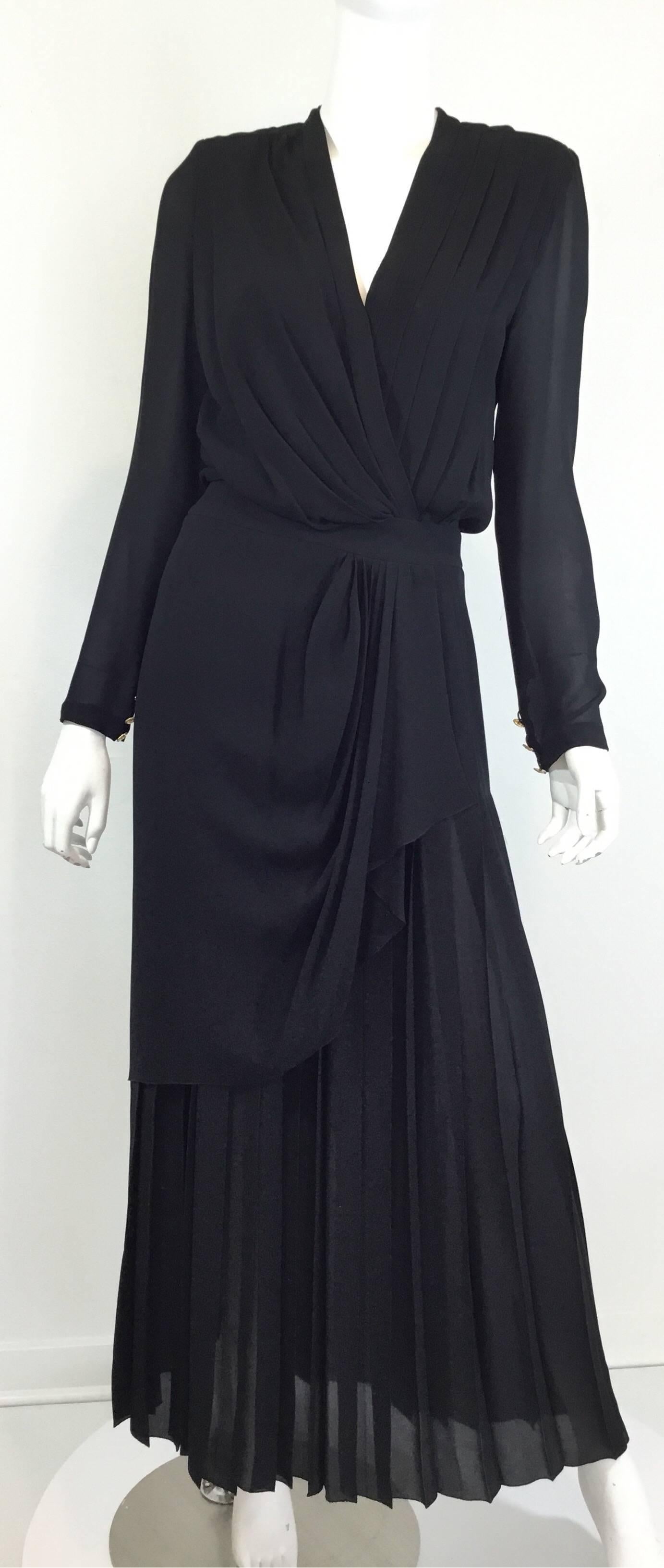 Vintage Chanel dress featured in black chiffon, crossover/surplice neckline with a pleated detail, a beautifully draped skirt with a zipper and hook fastening at the back, button closures at the back of the neck as well, gold buttons on sleeves, and