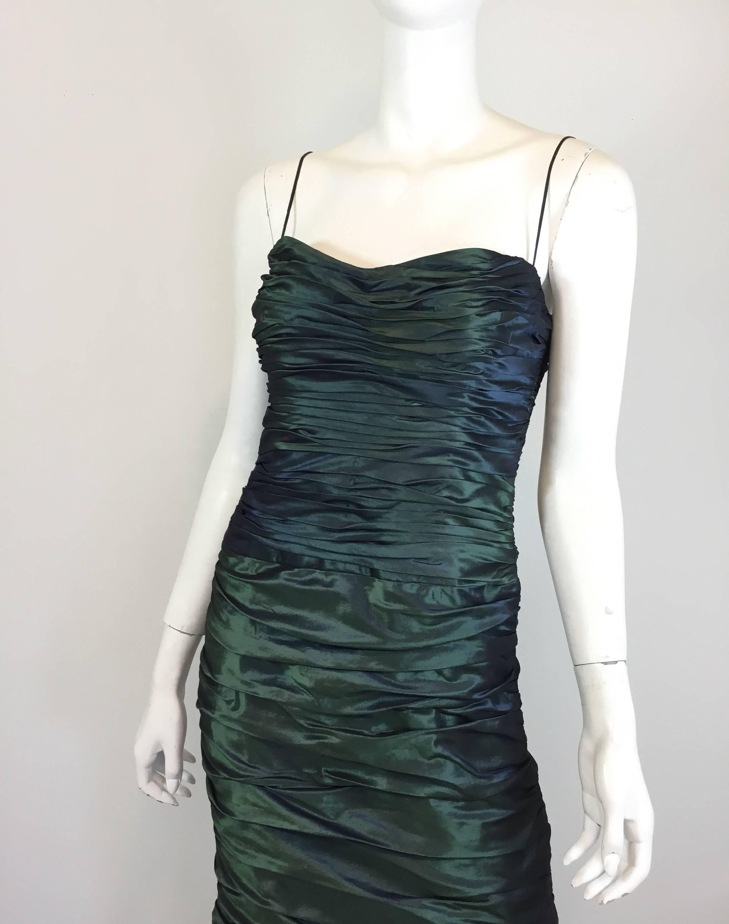Teri Jon dress featured in an iridescent green color with a Ruched/gathered design throughout, spaghetti shoulder straps and a back zipper fastening. Dress is labeled Size 6 and 100% silk. Fully lined.

Bust 30”, waist 28”, hips 35”, length 47”