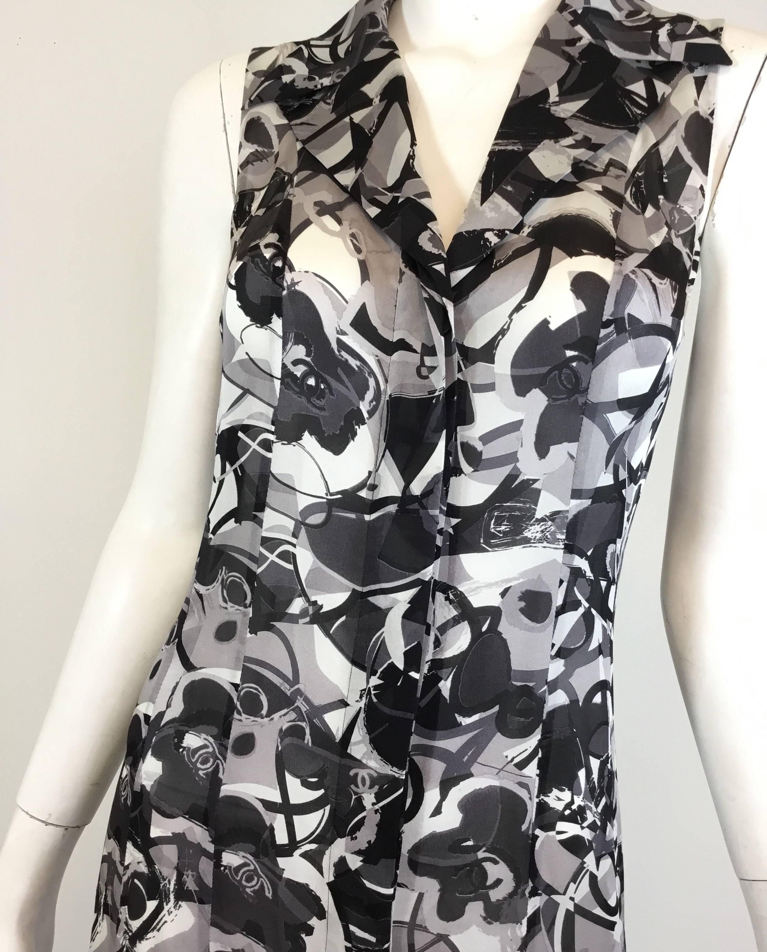 Chanel silk dress features a grey and black print throughout with concealed button front closures. Dress is labeled Size 38, made in France. Small spot at the front near left hip.

Bust 35”, waist 32”, hips 36”, length 41”