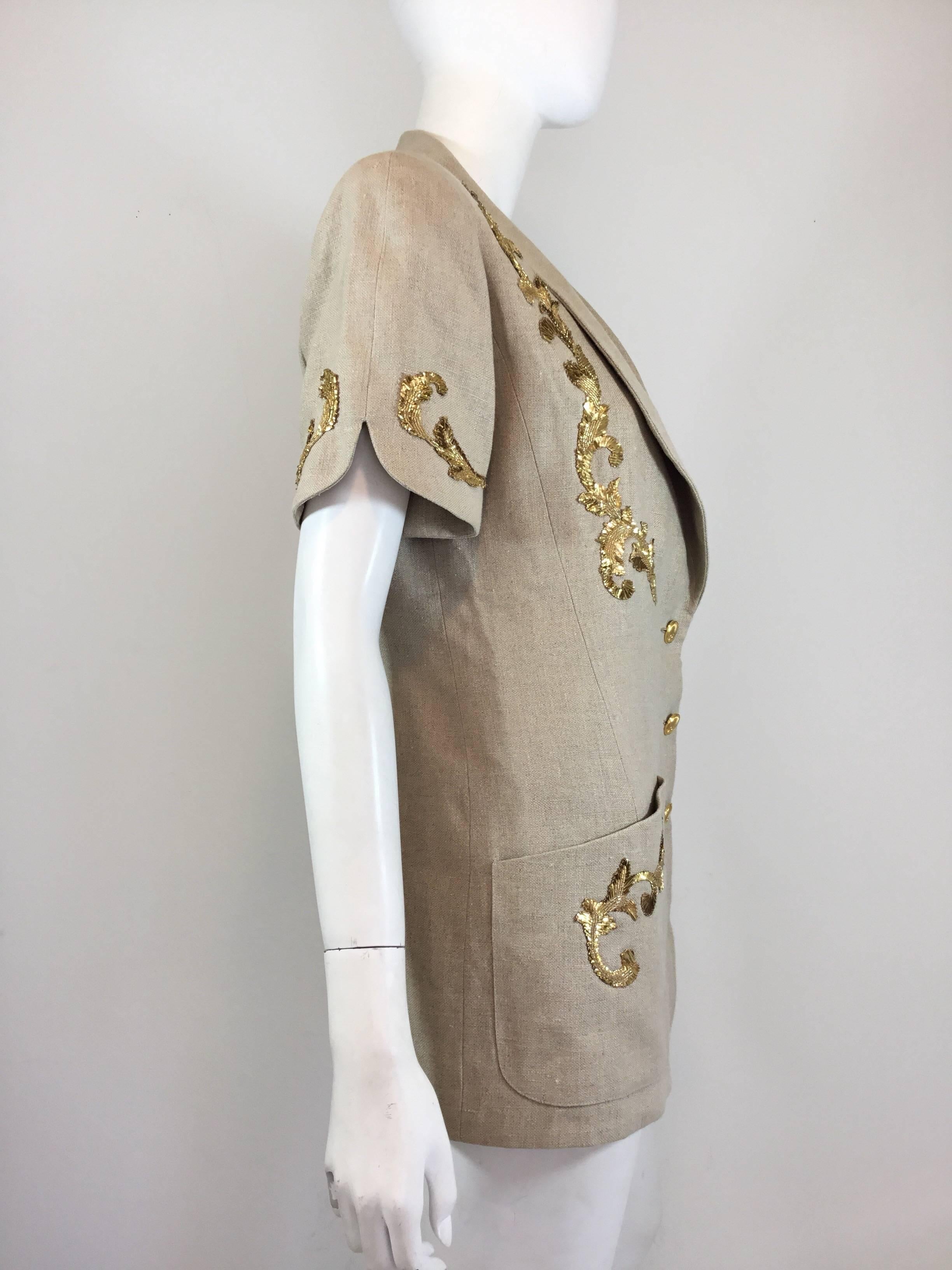 Chanel short sleeved jacket featured in beige linen with gold bead embellishing has button front closures, two slip pockets at the hem, and a full lining. Excellent condition.

Bust 38”, length 28.5”, shoulder to shoulder 16.5”