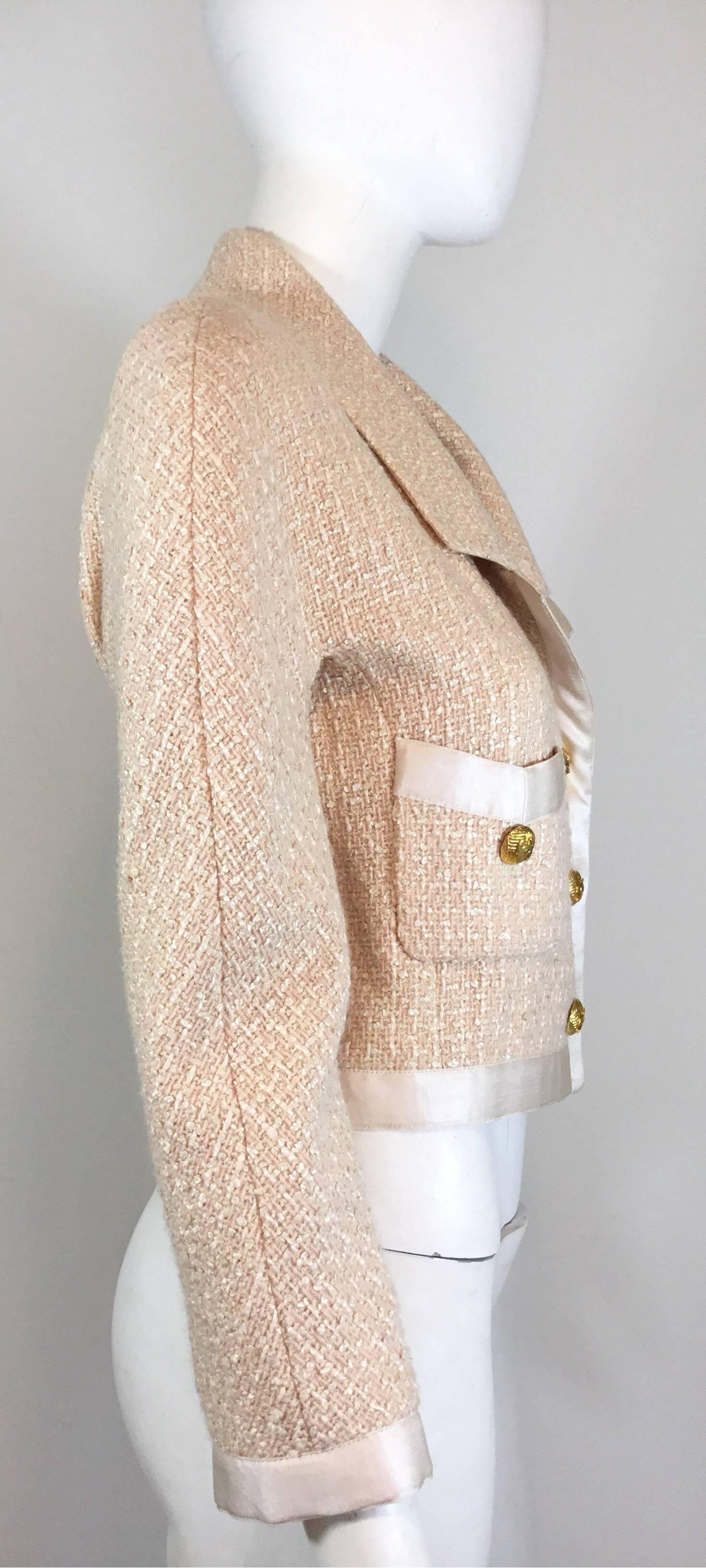 Chanel vintage jacket in light pink features satin trimming throughout with gold-tone button closures at the front, functional buttoned pockets at the bust, and a full silk lining. Jacket also has a chain trim along the hem.

bust 38'', length 20''