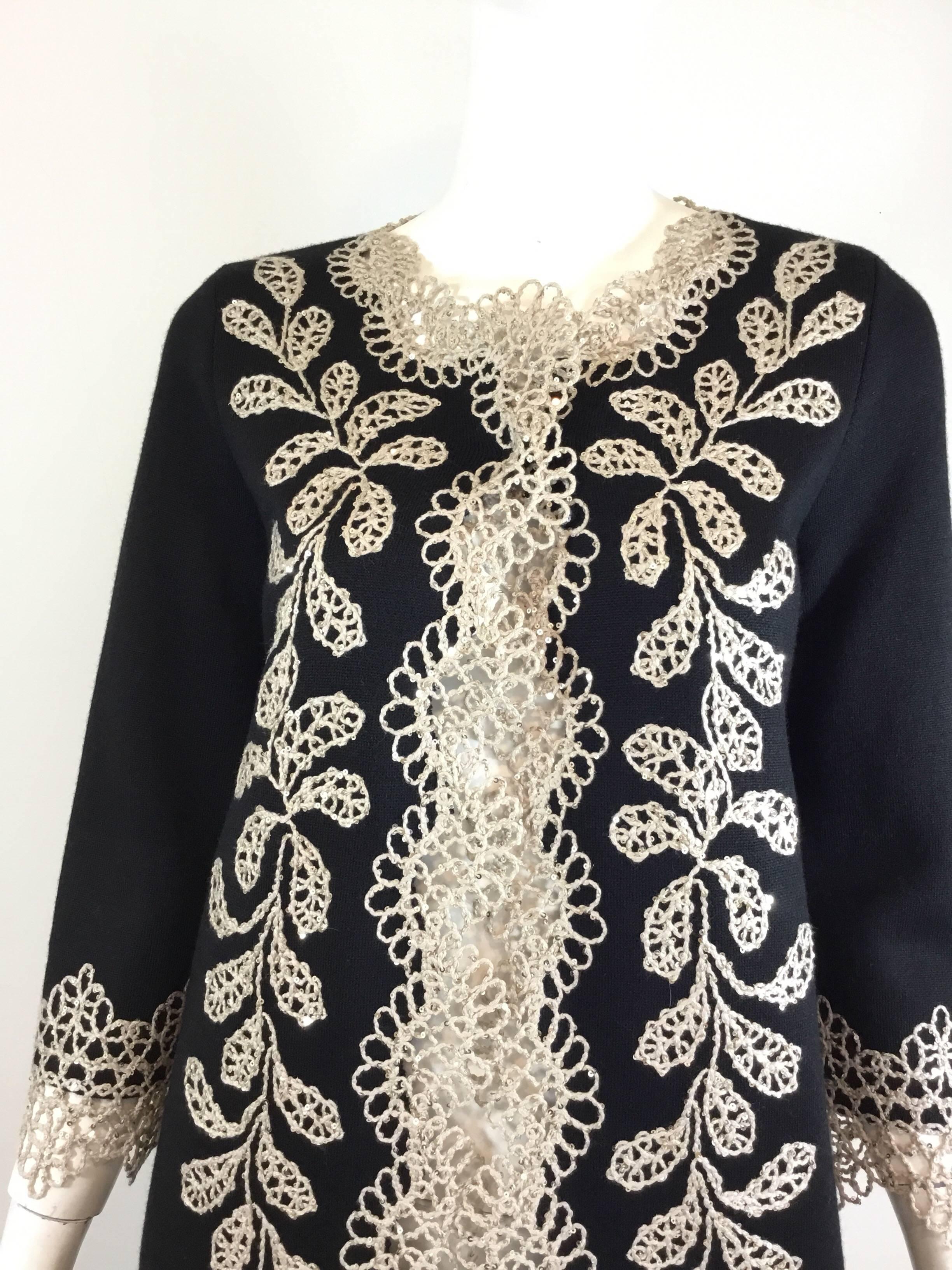 Oscar de la Renta long knit duster coat in black with a beige crochet trimming with sequins throughout the trim. Very nice quality densely woven (will not pill) wool knit. Coat  has a single snap button closure. Labeled a size small, made in Italy,