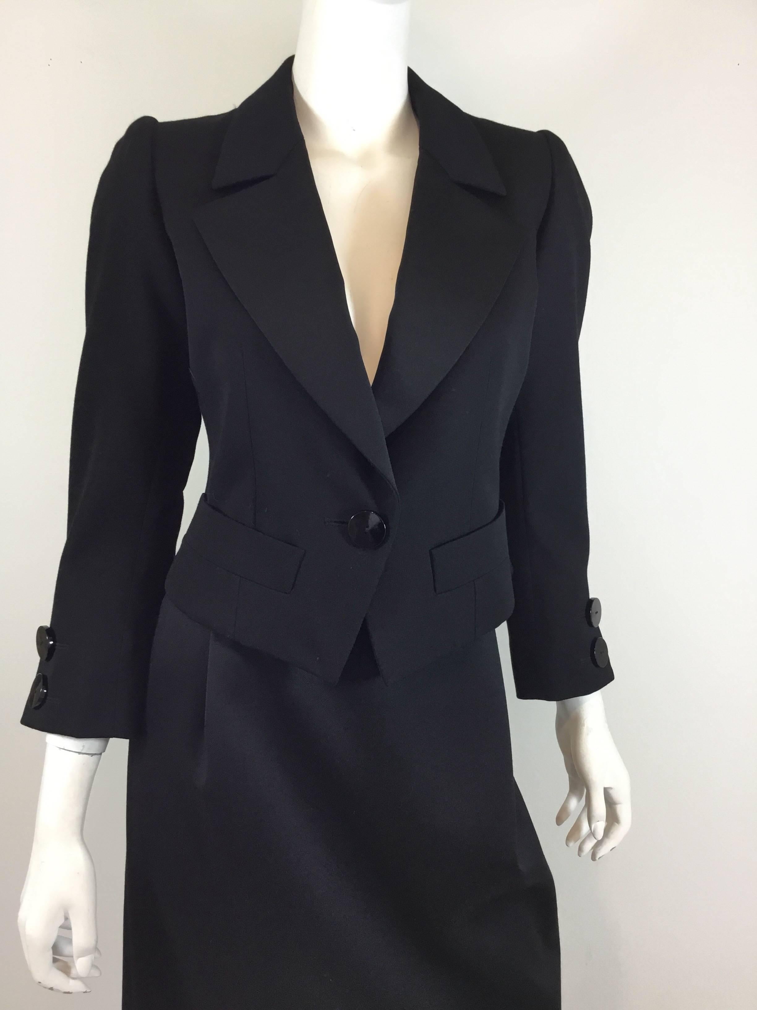 Yves Saint Laurent tuxedo jacket has a single button closure and two slip pockets at the hem. Skirt has a back zipper and button fastening. Skirt and jacket are fully lined and are composed of 100% wool. Size 36, made in France. 

Jacket- bust 36”,