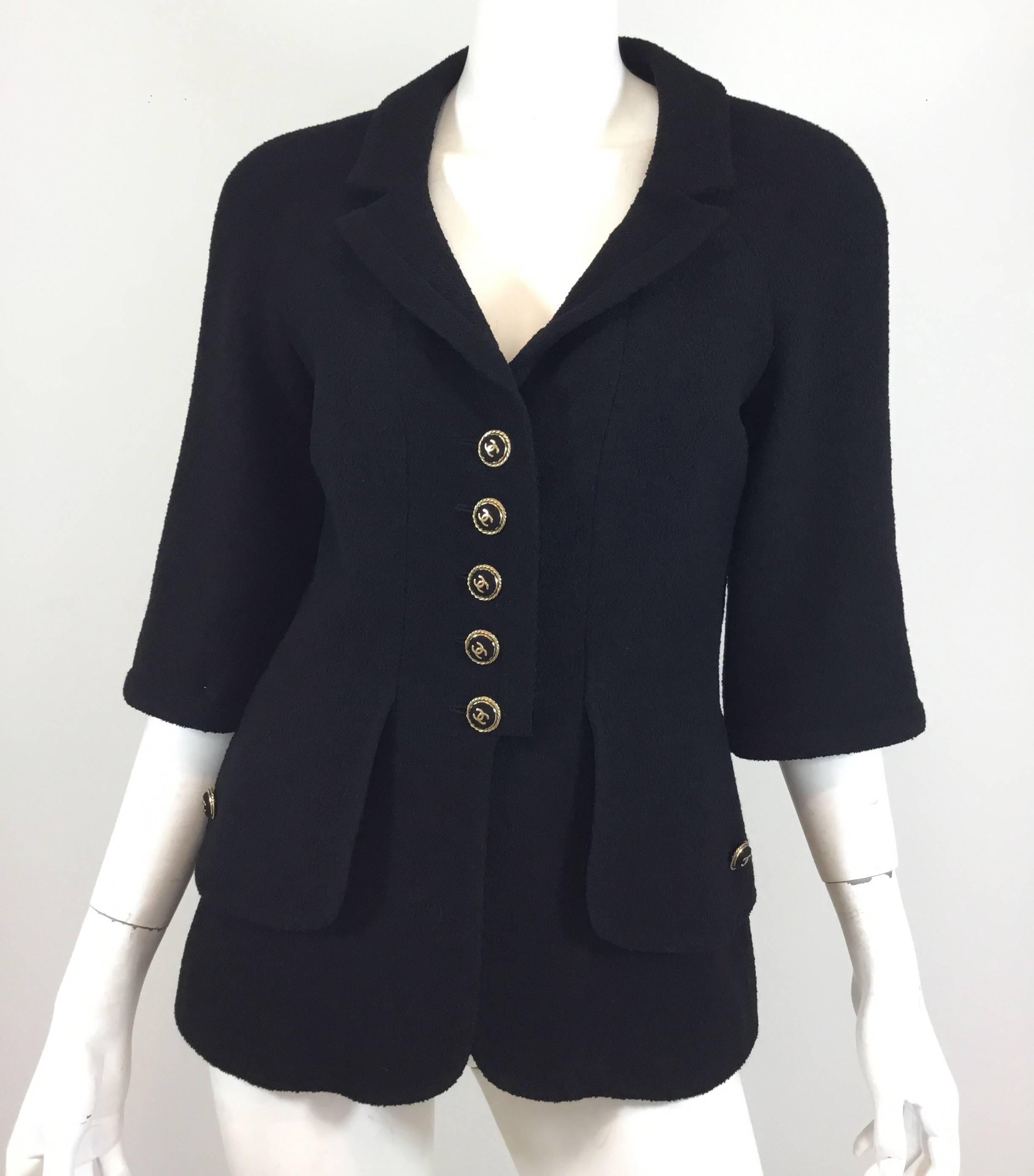 Chanel jacket featured in black has 3/4 length sleeves, wool-covered button closures at the front and on the pockets. Jacket  is fully lined, labeled size 40, and made in France.

Bust 36'', sleeves 18'', length 26''