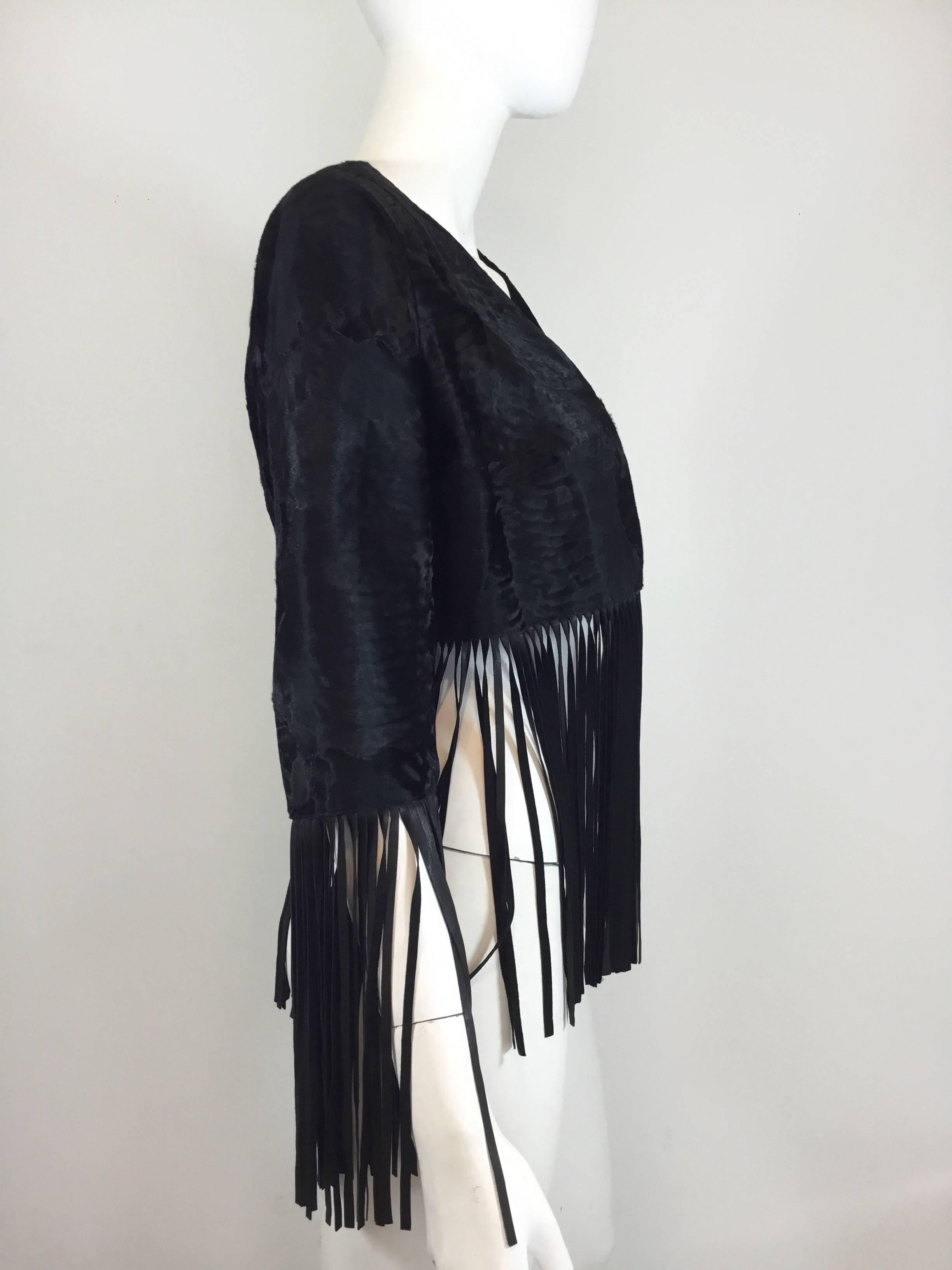 Bisang Couture jacket featured in a black broadtail fur with leather fringing along the sleeves and hem. Fully lined.

Bust 34''. sleeves 16'' (26'' including fringe trim), length 14'' (25'' including fringe trim)