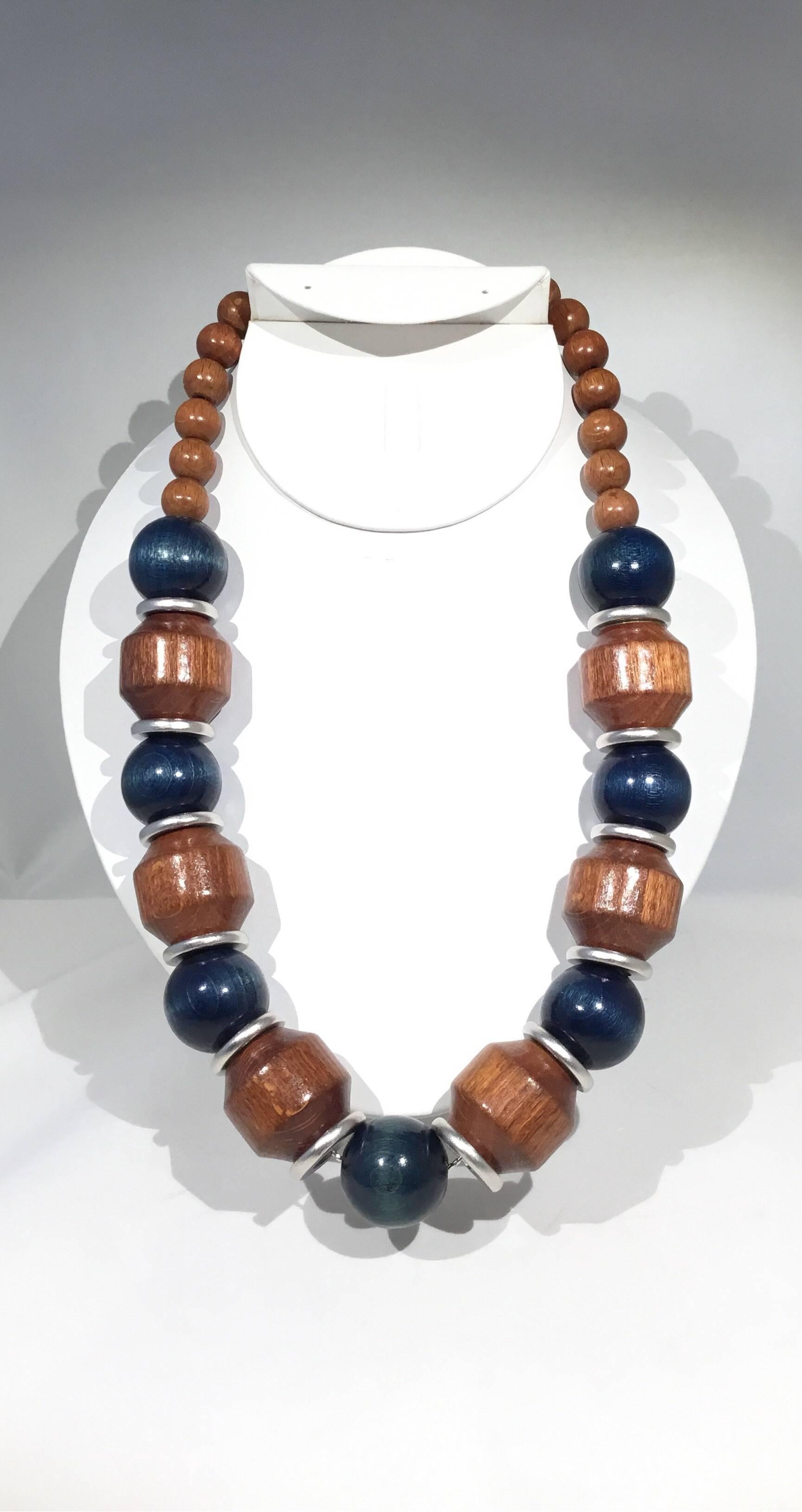 YSL vintage wood necklace has silver-tone rings, Natural and blue wood beads with a hook closure. YSL signature clasp. Necklace measures approximately 23 inches. Excellent condition.