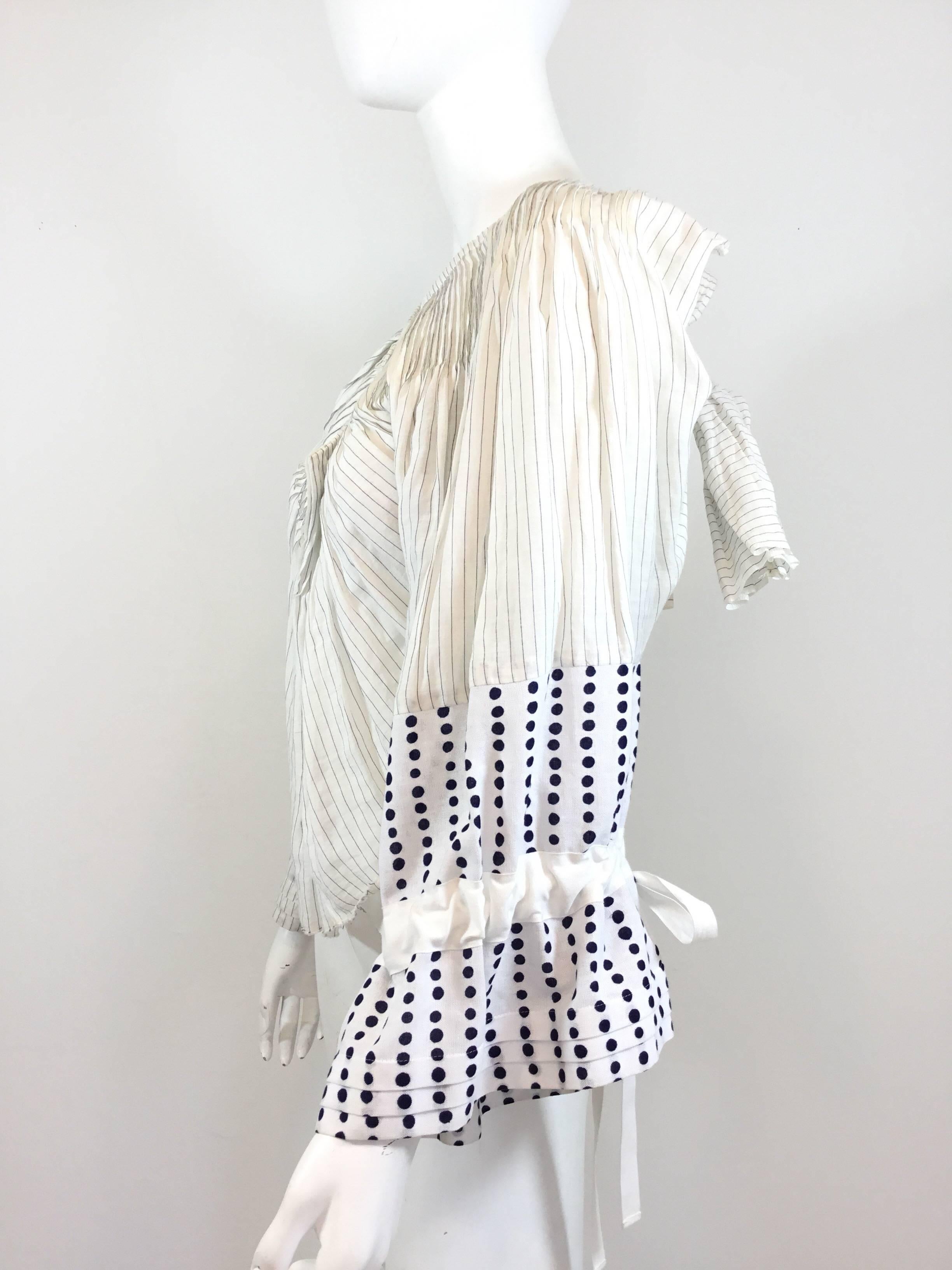 Tao Kurihara Comme des Garçons Blouse 2007

Cotton shirting material peasant blouse with striped and polka dot patterns in blue and white lightweight shirt fabric. Pleating throughout, unfinished hem, peasant sleeves with drawstring wrist ties.