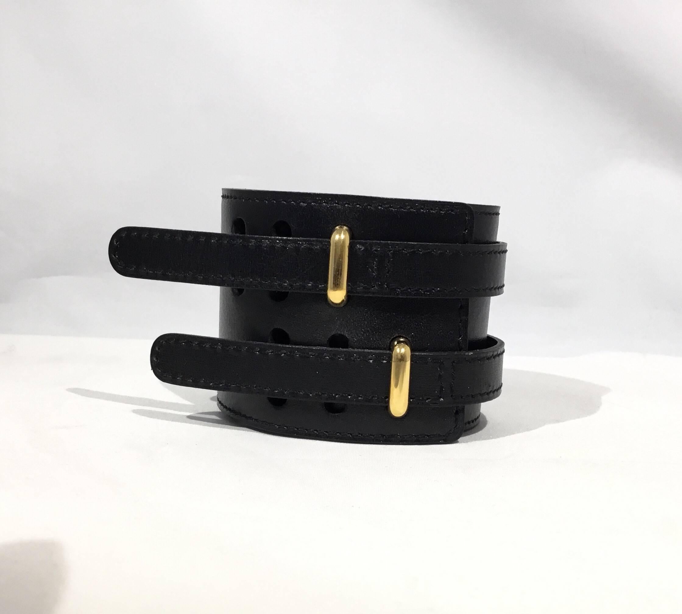 Hermes Paris black leather bracelet with gold hardware. Bracelet is adjustable and measures approximately 10 inches. Made in France. Stamps: M, F in a square.