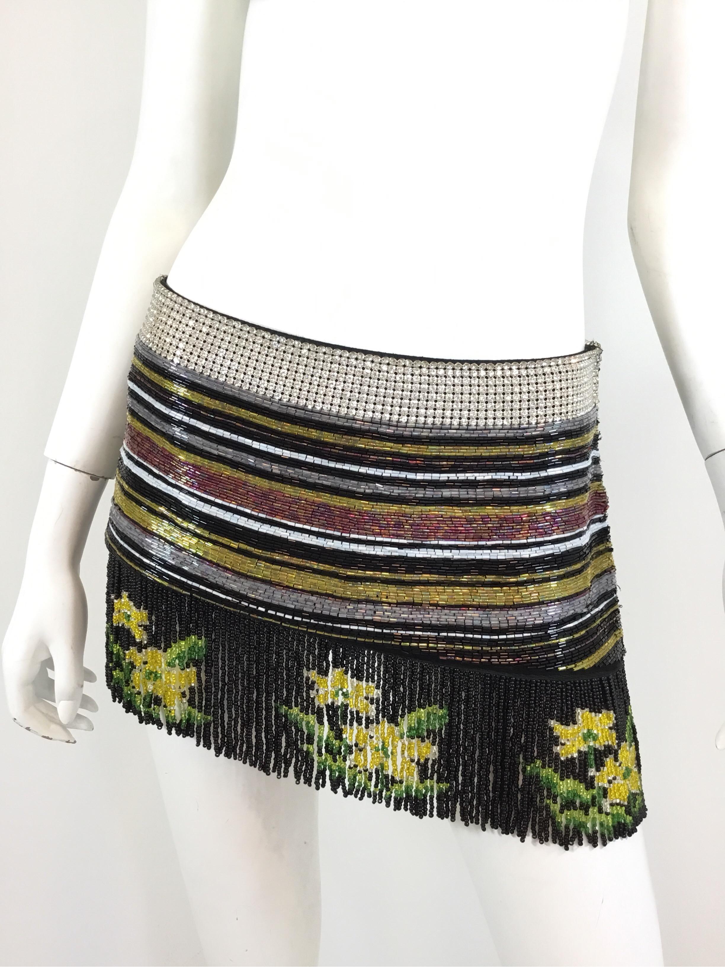 Dolce & Gabbana skirt from Spring/Summer 2000 collection. Multicolor and fully beaded with a fringed hem, rhinestone waist band with a side zipper closure, size 42, and fully lined. Made in Italy.

Measurements:
Waist 33”, hips 38”, length 12”