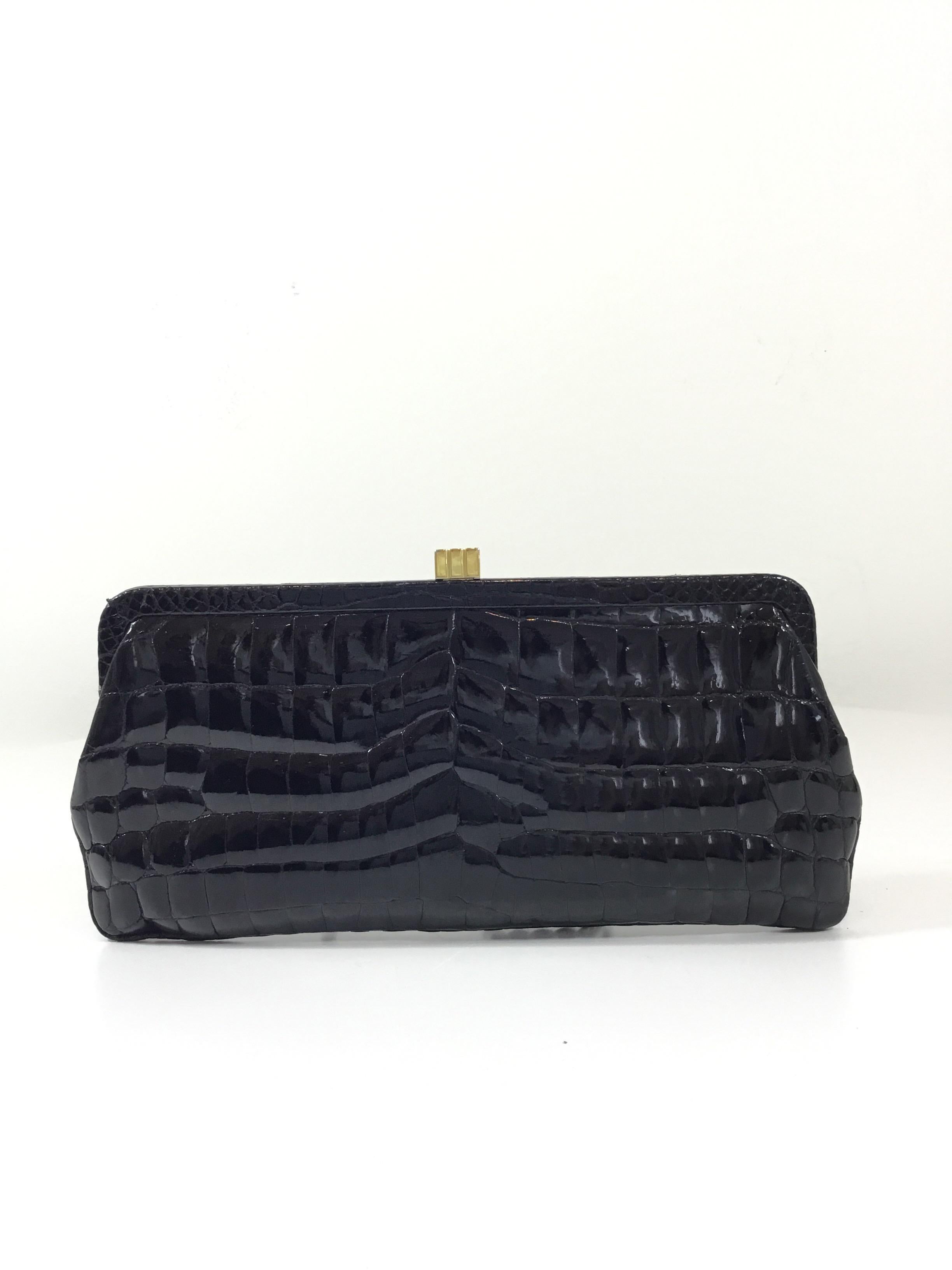 Lambertson Truex crocodile clutch in black with a gold-tone top clasp closure. Blue suede leather lining with one zipper pocket. Clutch is in mint condition -- No major flaws. Made in South Africa. Retail $4,200

Measurements: 
10'' x 5''