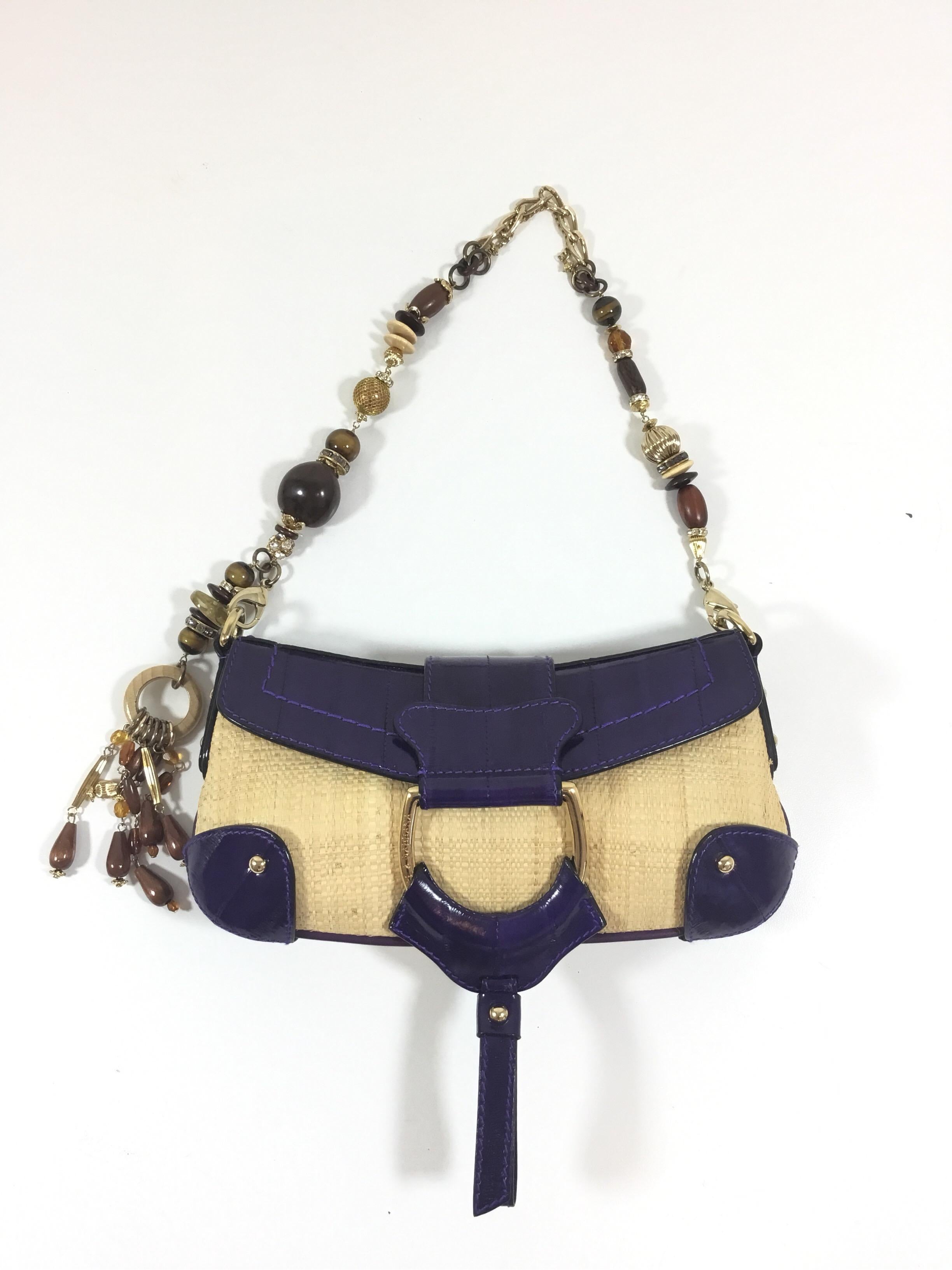Dolce & Gabbana purse featured in straw and eel skin in purple with a bead and jewel gold chain handle, handle has clips at each end for easy removal, flap and snap stud closure. Interior is fully lined in a jacquard fabric with one slip pocket.