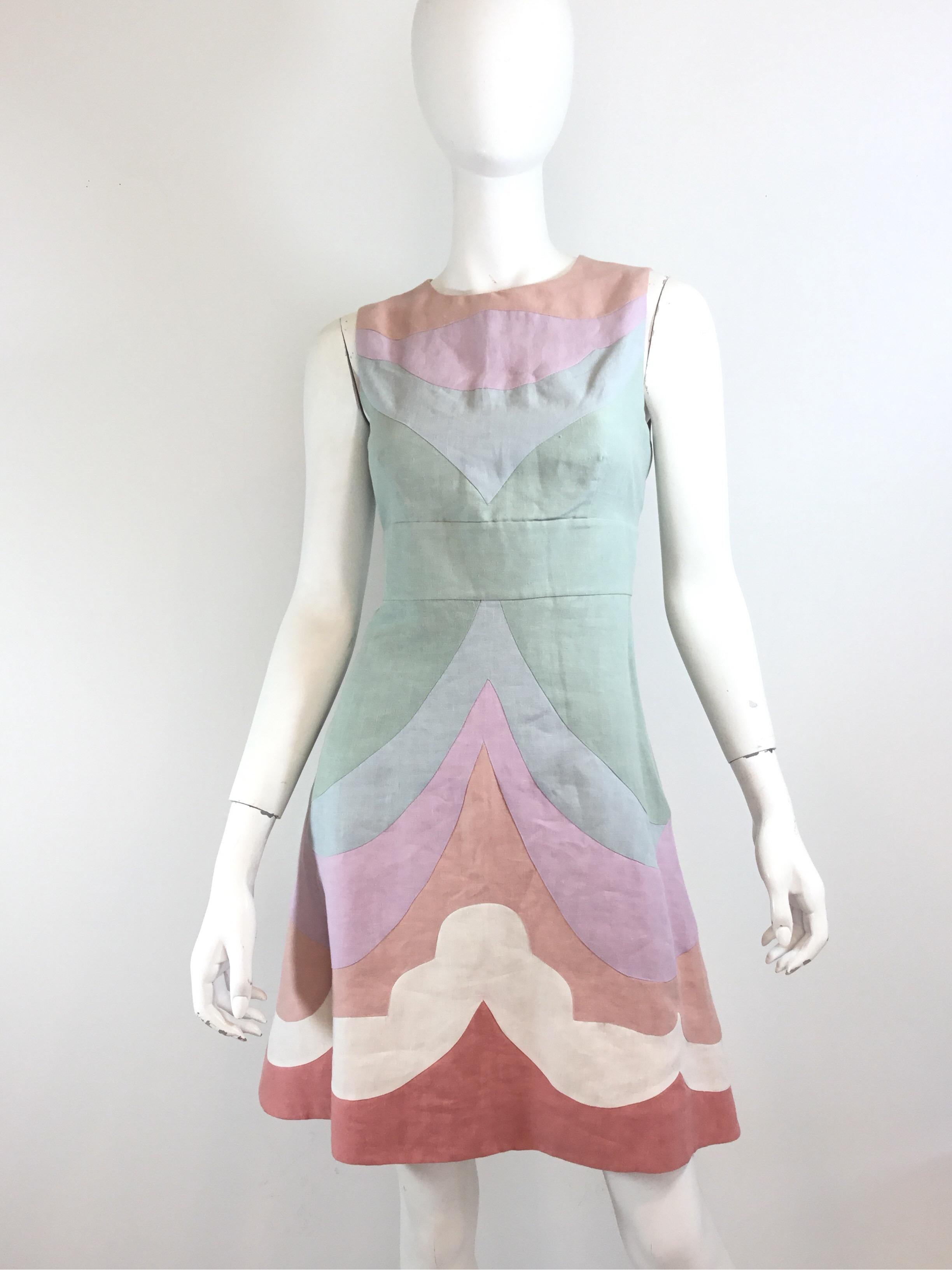 Valentino dress features a scalloped panel in pastel colors, composed of 100% linen, and labeled size 8. Dress has pockets at the waist a back zipper and hook fastening. Made in Italy. 

Bust 36”, waist 32”, hips 38”, length 35”