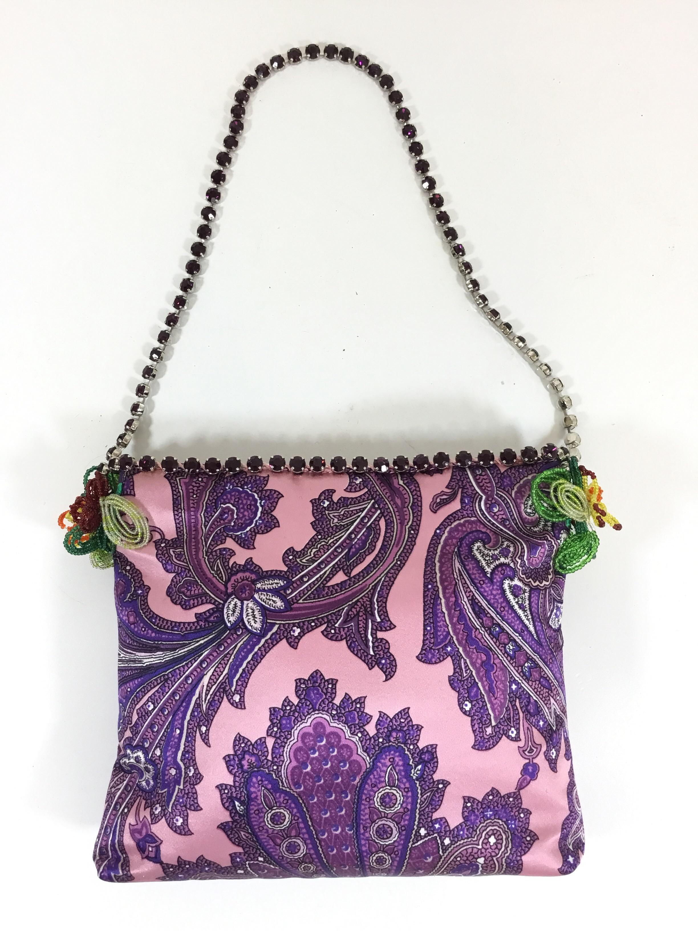Dolce & Gabbana Evening Bag in purple with a rhinestone handle and beaded detail on the sides. There is a concealed magnetic closure, full lining in satin with one small slip pocket. Made in Italy


Measurements:
8’’ x 1’’ x 7’’, strapdrop 9’’