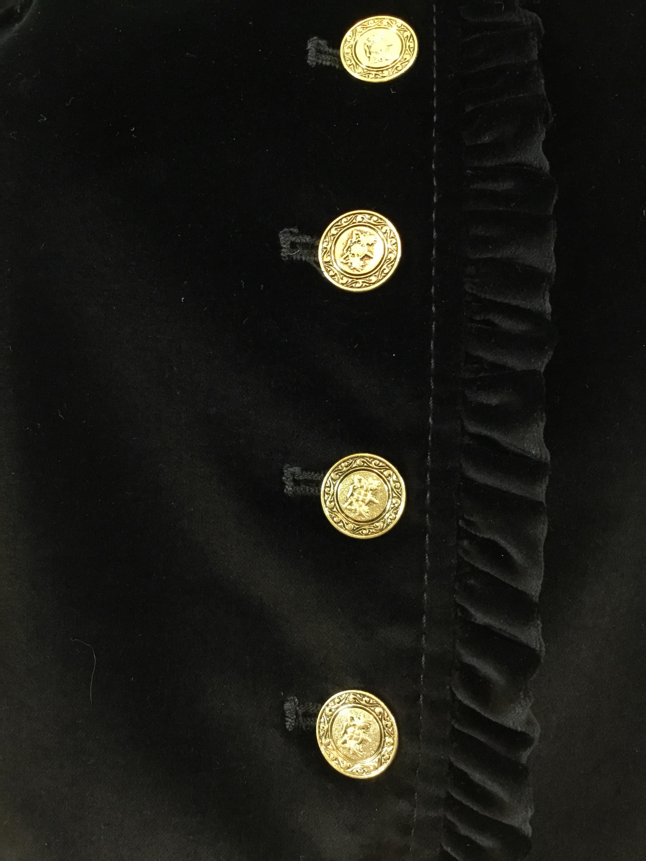 Dolce & Gabbana velvet jacket in black with gold tone button fastenings and a ruffled trim. Jacket has a total of 3 buttoned pockets that have not been cut for use. Fully lined in signature leopard print. Made in Italy, size 44.

Bust 36”, sleeves