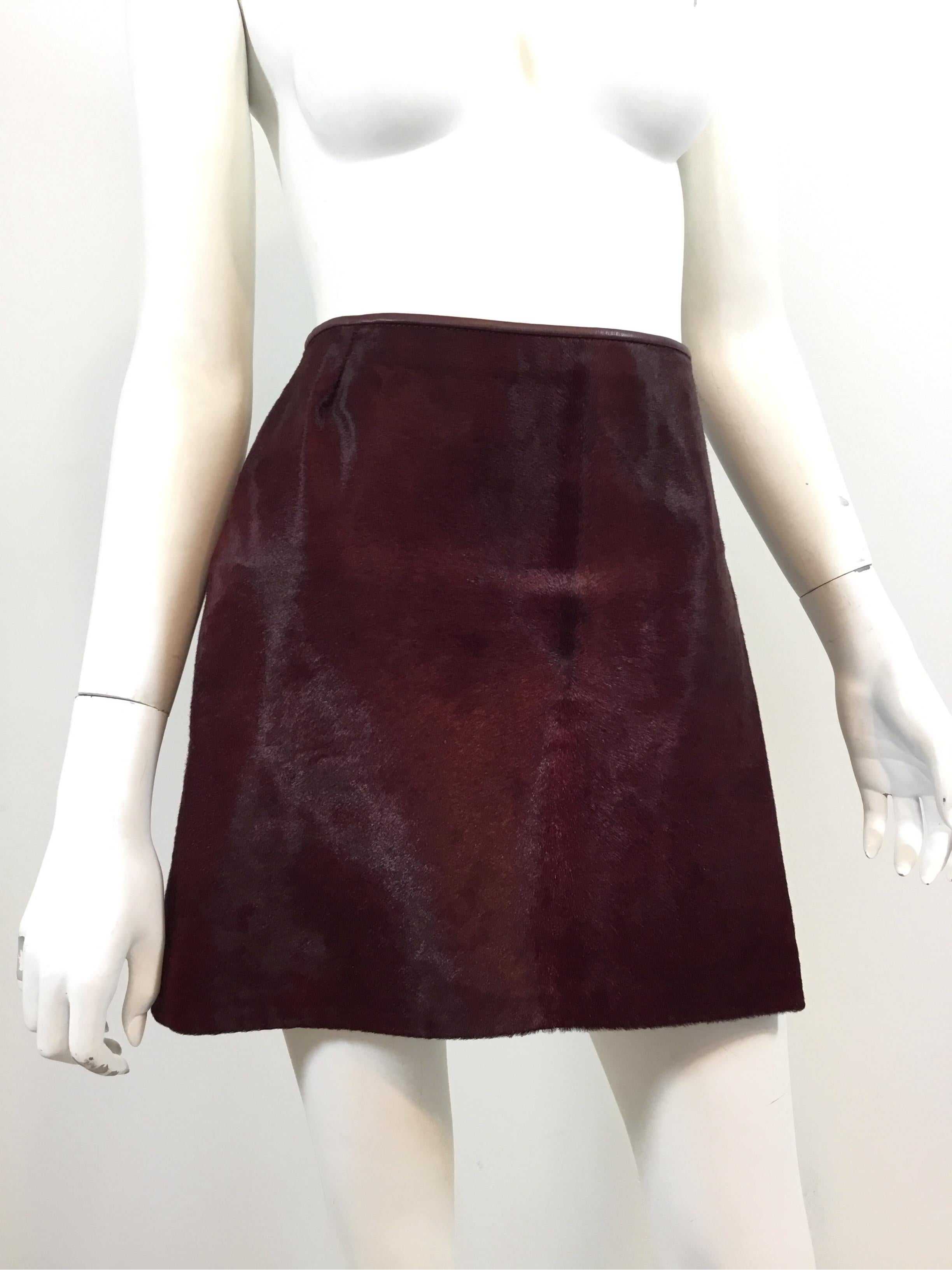 Dolce & Gabbana Vintage mini skirt featured in a maroon/burgundy color with pony fur throughout. Leather trimming along the waist and a back zipper fastening. Fully lined in signature leopard print. Skirt was made in Italy and is labeled a size 40.