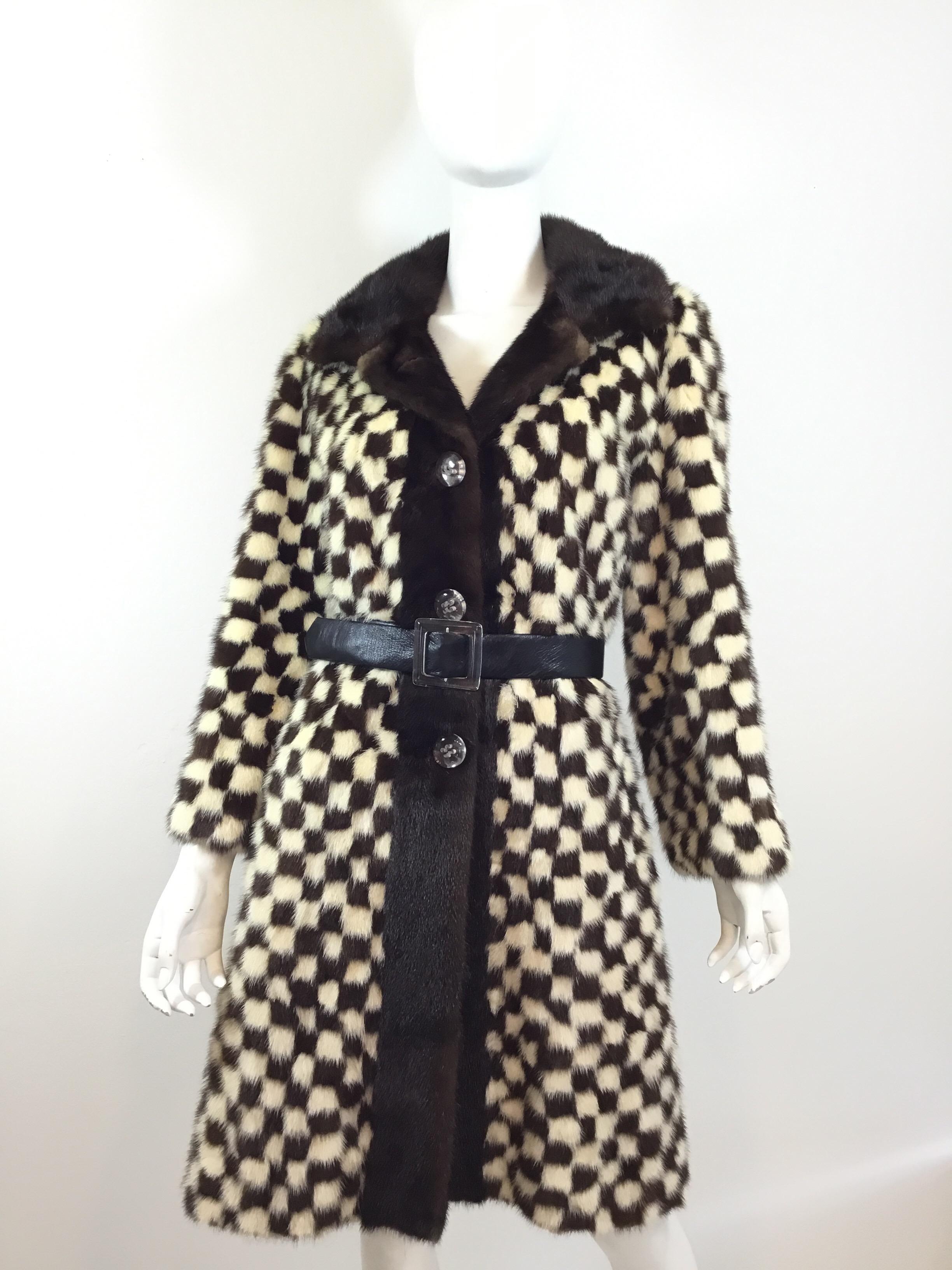 Vintage coat featured in a brown and Cream mink fur with a checkered pattern design throughout, large clear button closures, and an optional leather belt that has a clear buckle. Coat is fully lined and in excellent vintage condition.

Bust 42”,