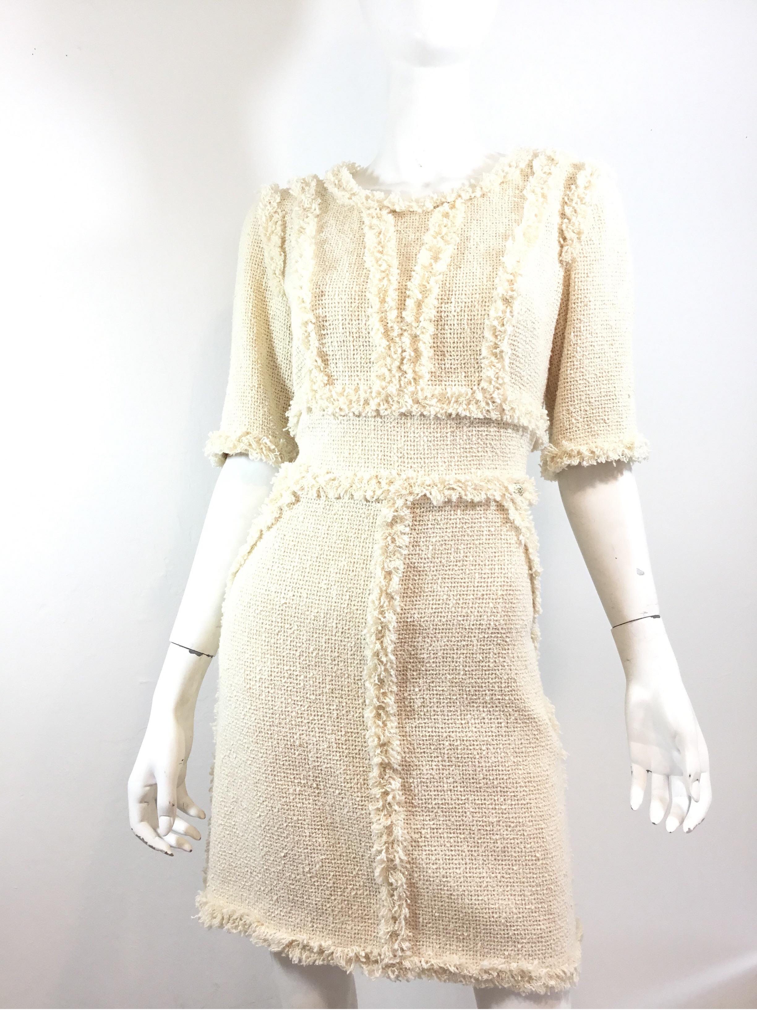 Chanel Tweed Dress featured in a Cream/ivory color with fringed trimming. Dress is fully lined in silk, cotton with nylon blend knit with a back zipper fastening, and is a size 42. Made in France.

Bust 36''
Waist 32''
Hips 36''
Length 35''
Sleeves