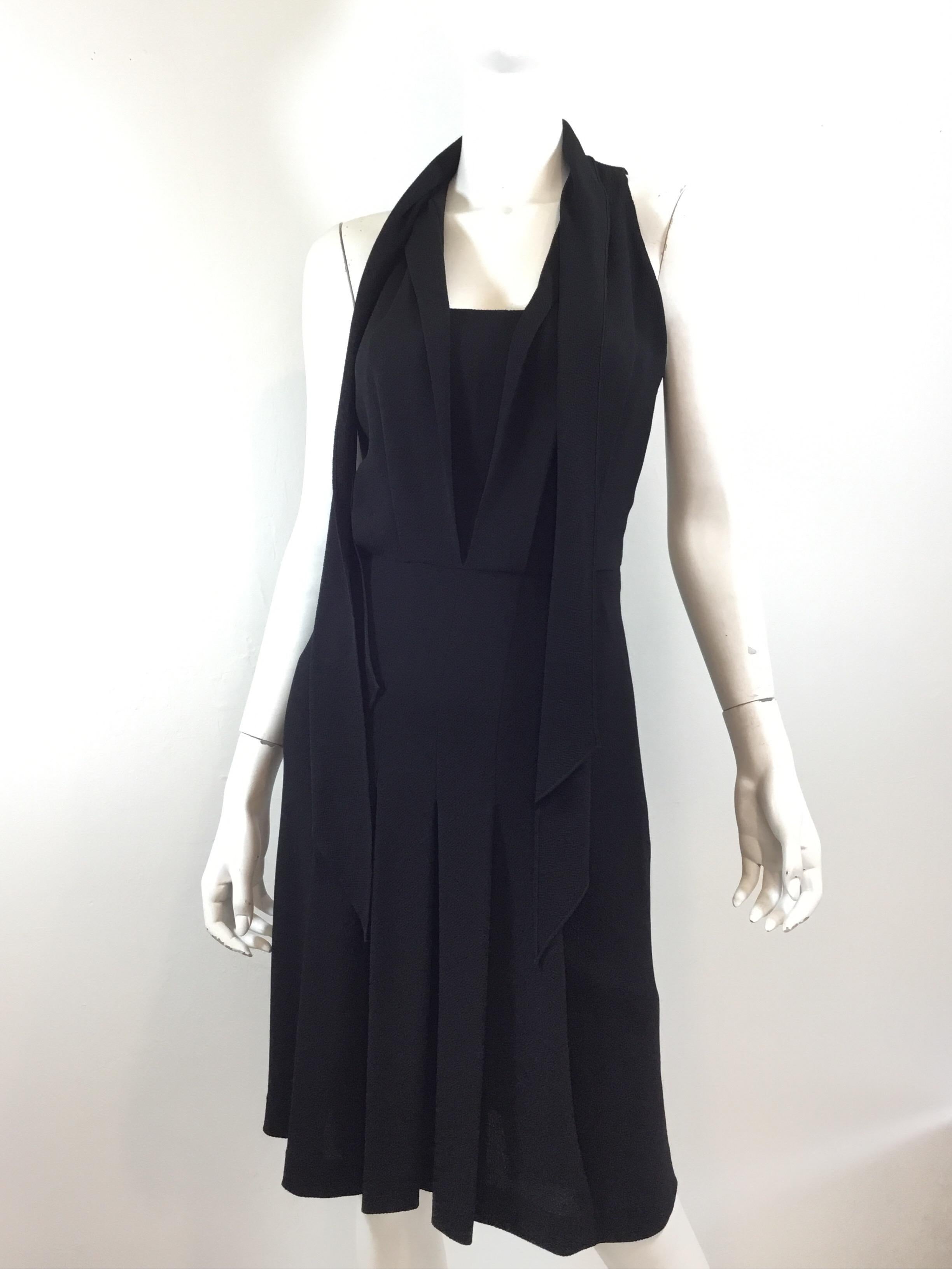 Hermes little black dress in a silk crepe fabric with a neck tie detail. Dress has a pleated skirt and a side zipper fastening. Size 38, Made in France.

Bust 32''
Waist 28''
Hips 36''
Length 40''