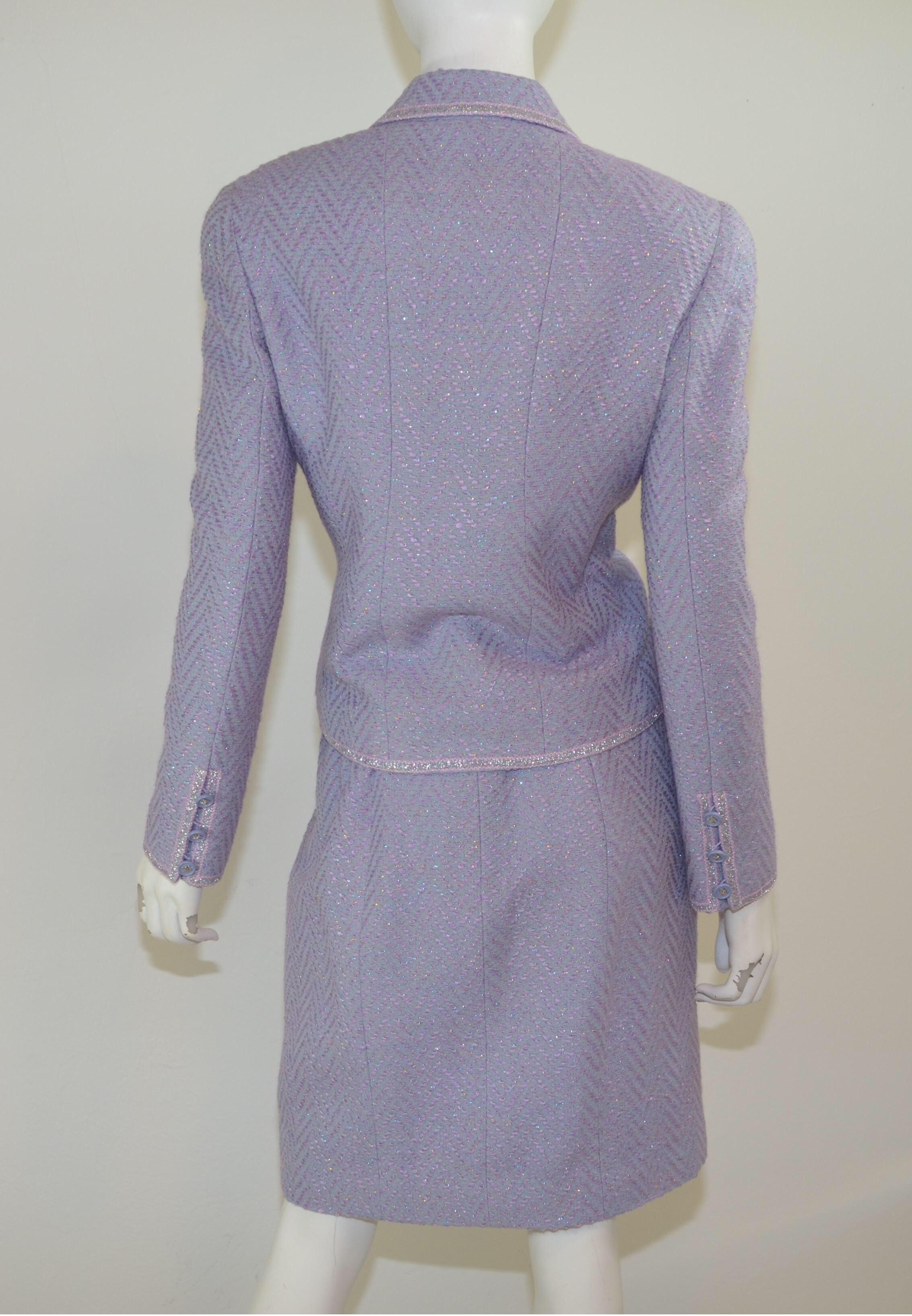 Chanel skirt suit 1997 P in a beautiful purple fantasy Tweed with purple and silvertone button closures on the jacket and a back zipper and hook fastening to the skirt. Skirt suit is labeled a size 44, made in France.

Jacket:
Bust 41”, sleeves 24”,