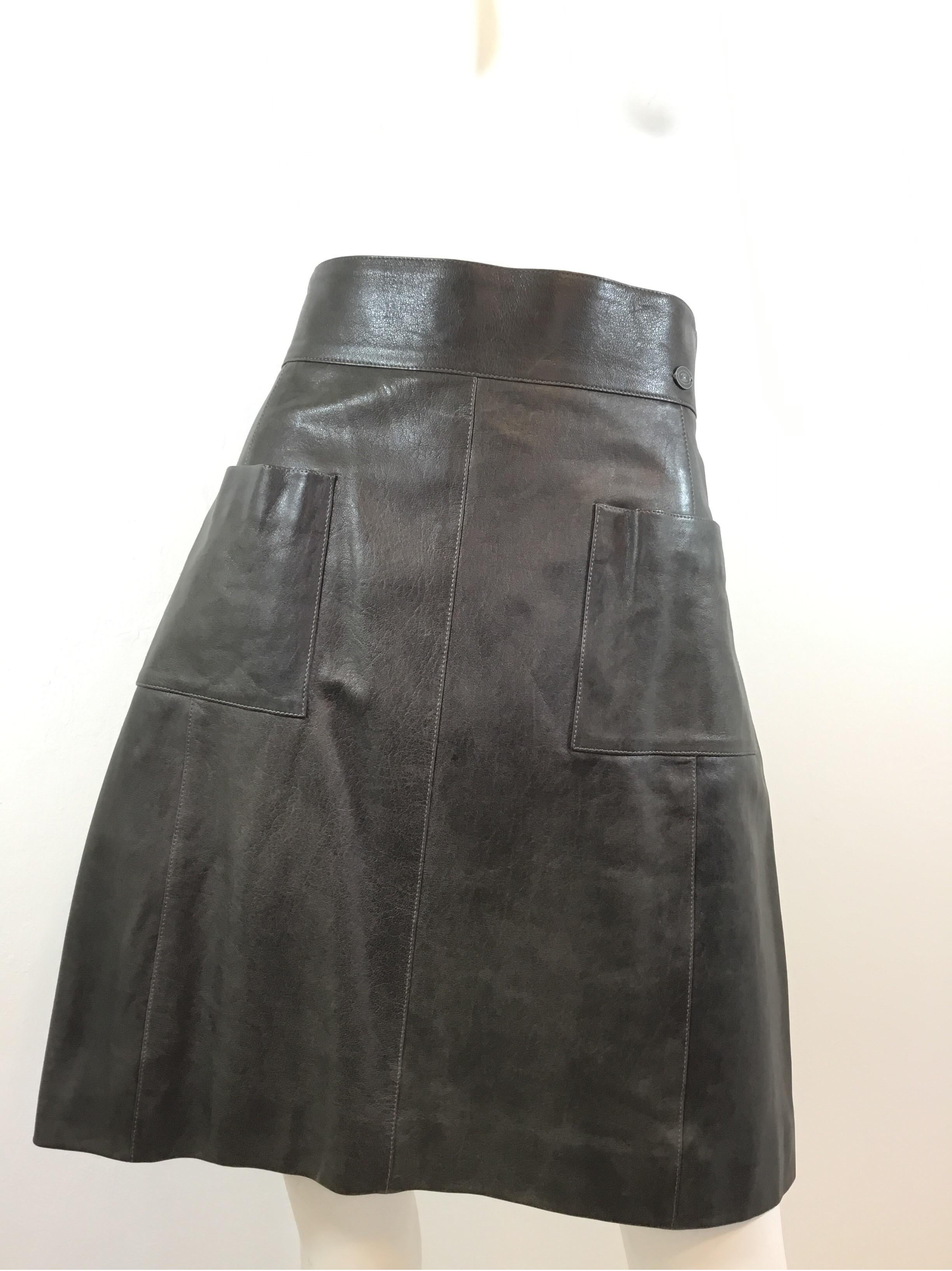 Chanel lambskin leather skirt is featured in an Olive green color with two front slip pockets and a back zipper fastening. Skirt is a size 42, 100% lambskin and lined in 100% silk. Made in France.

Waist 31”, hips 35”, length 20”