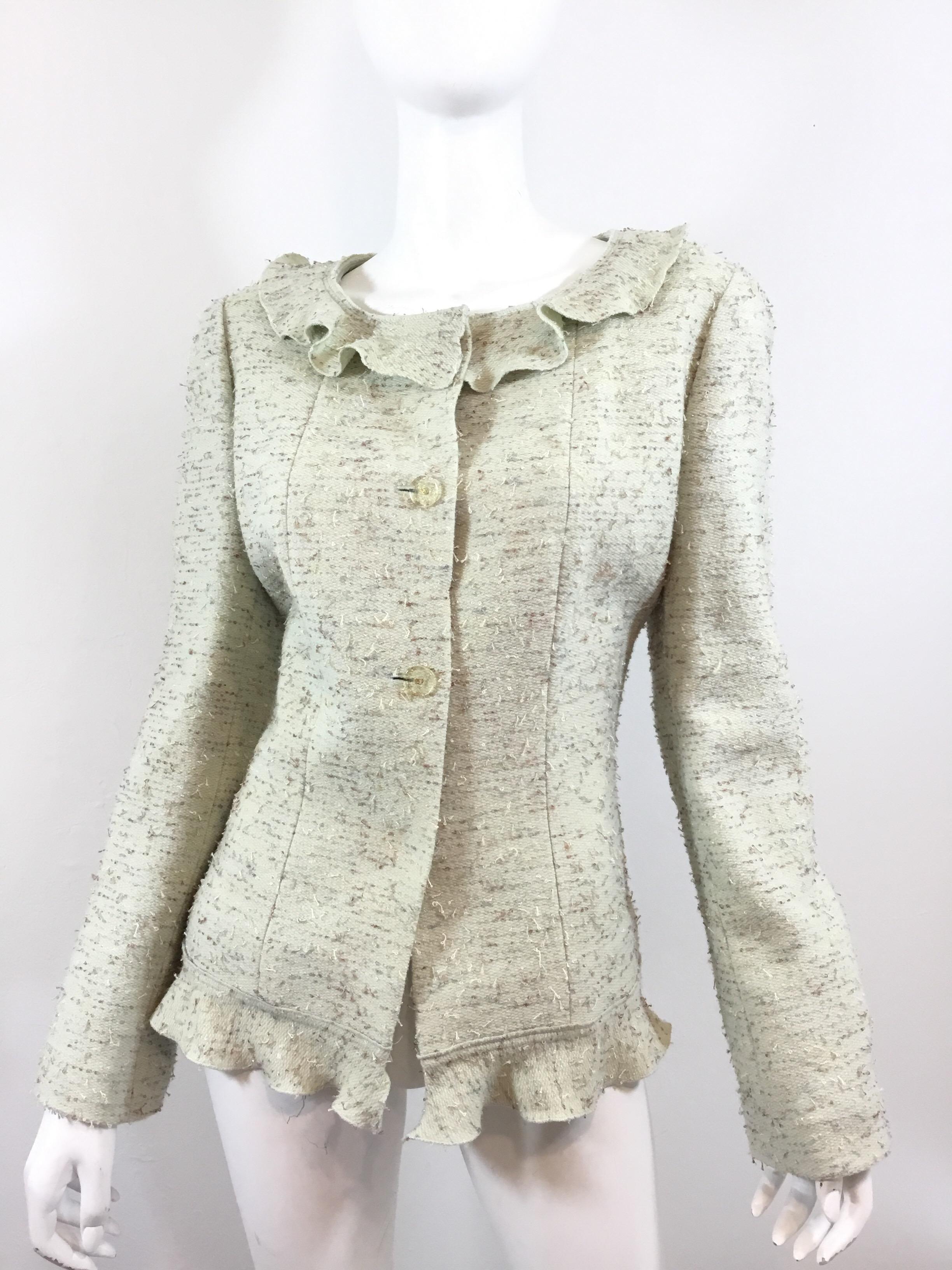 Chanel jacket featured in a light mint green color with button closures along the front with a ruffled collar and hem. Jacket is fully lined in silk and composed of: 83% wool, 15% polyester, and 2% nylon. Excellent condition.

Bust 40”, length 24”,