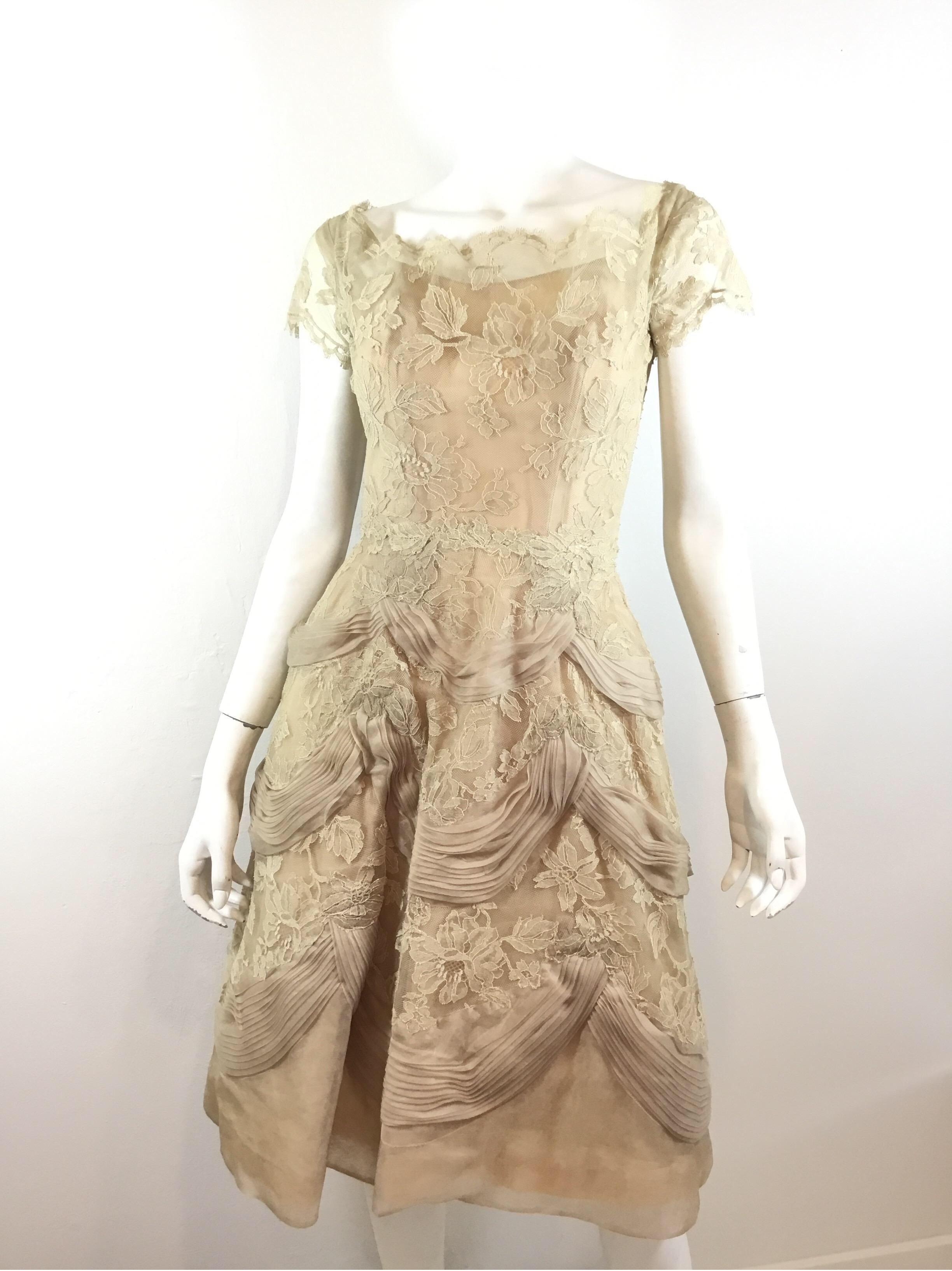 Ceil Chapman 1950's vintage dress featured in beige with lace, ribbon and organza fabric, boat neckline and a back zipper fastening. Dress has a full lining and a tulle lining for the skirt. There is some tearing to the lining on the inside due to