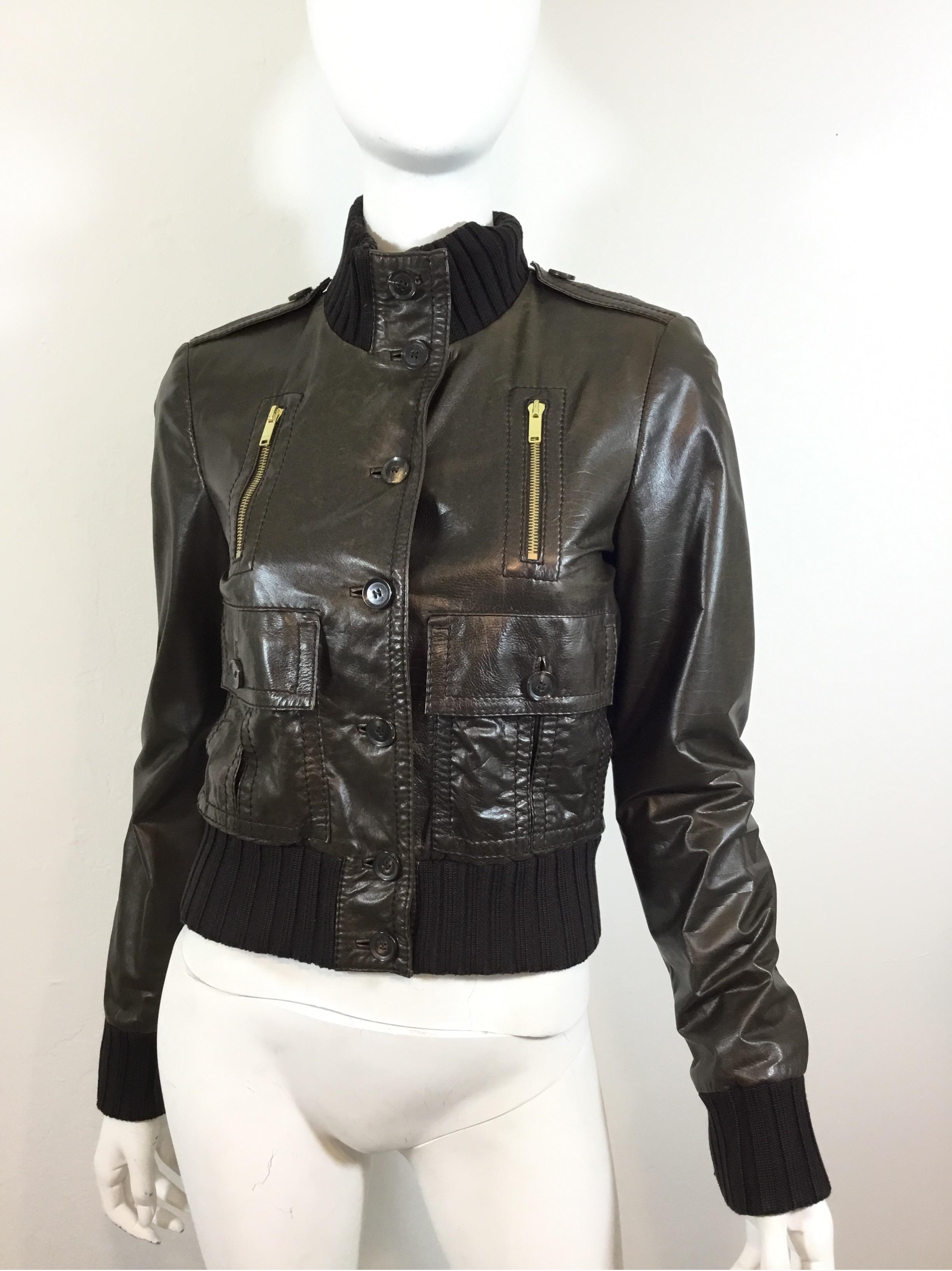 Gucci bomber jacket featured in brown leather with a ribbed knit hem, button closures along the front and on the patch pockets, functional zipper pockets at the bust. Fully lined. Jacket is a size 40, made in Italy. 

Bust 37'', sleeves 25'',