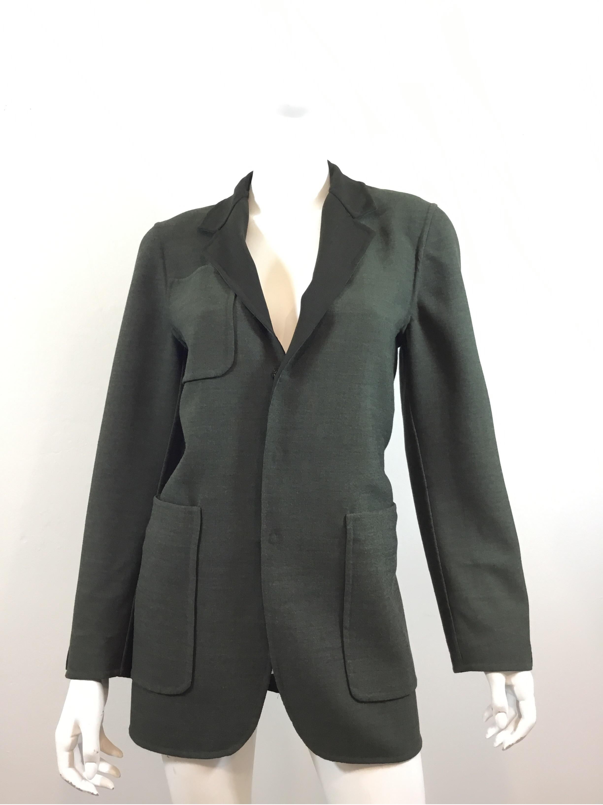 Jean Paul Gaultier Jacket is featured in an Olive green color and is reversible with concealed snap button closures along the front and on the cuffs. Jacket has one pocket on the right bust and two pockets at the hips, labeled size US 6/ IT 40,