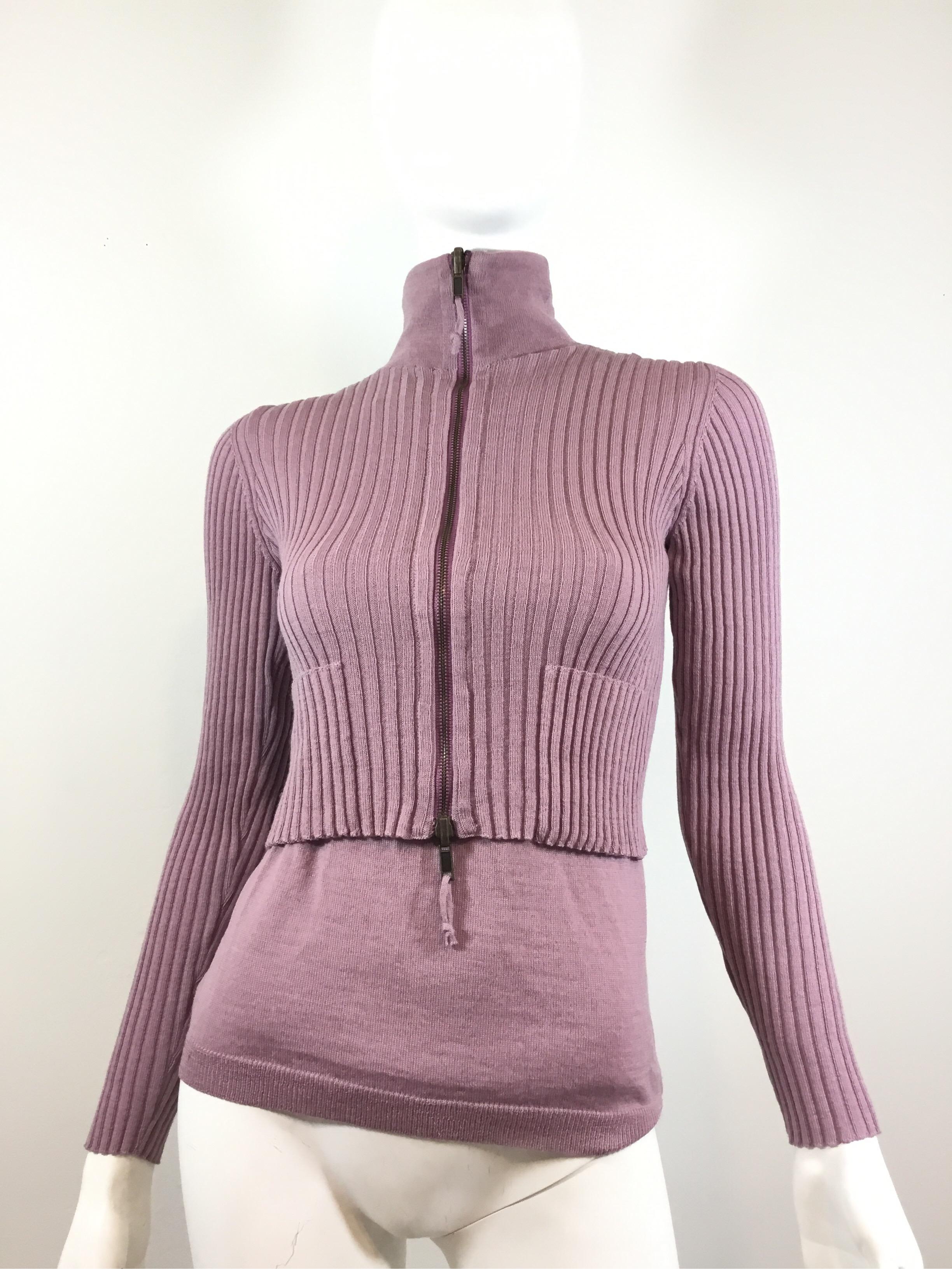 Jean Paul Gaultier sweater comes attached with a shell to, two front pockets, and a zipper fastening. Sweater is featured in a mauve purple color, labeled a size small, made in Italy, and composed of 100% wool.

Bust 29”+ (with room for stretch),