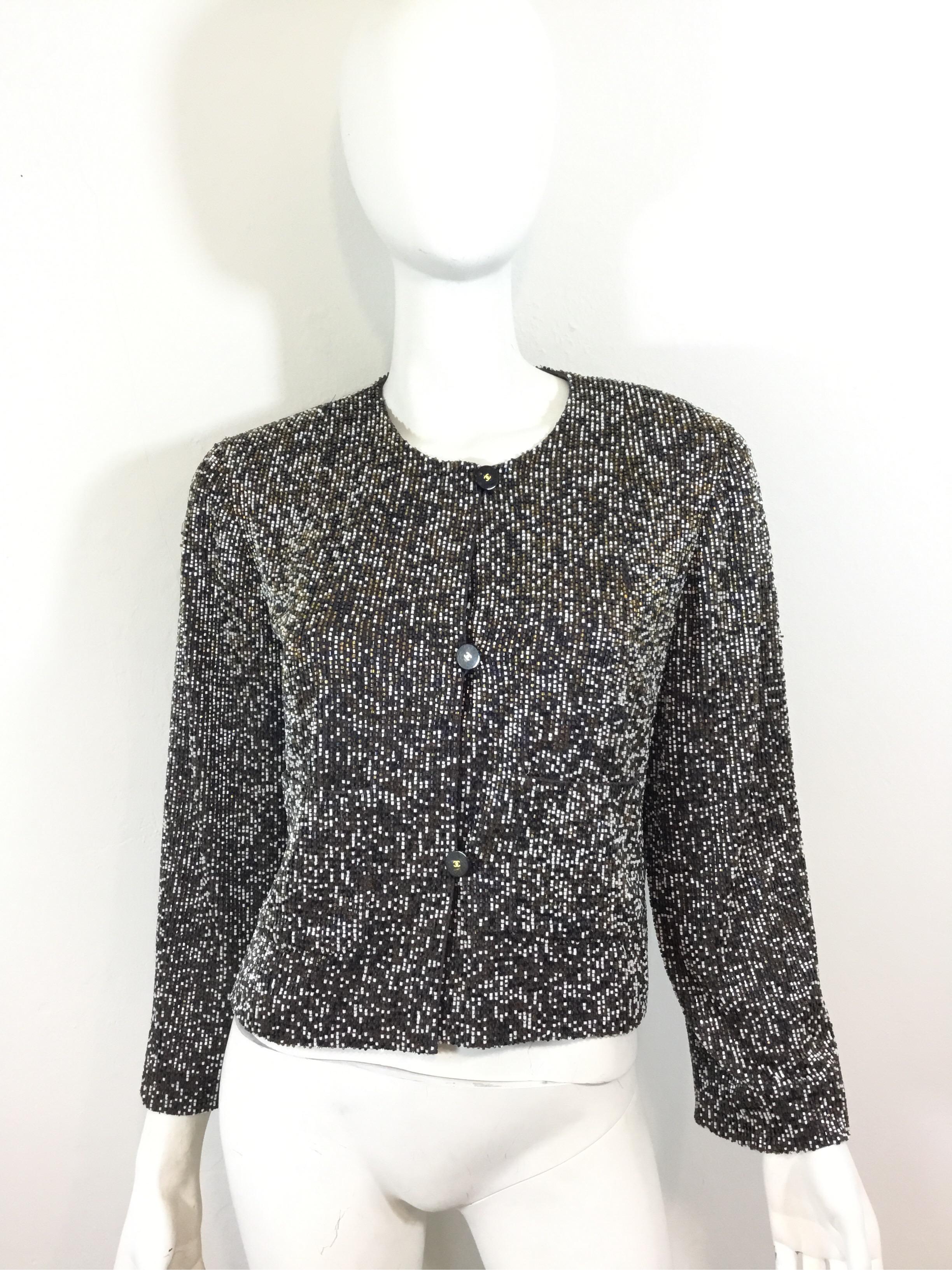 Chanel jacket is fully beaded with gold/bronze, blue, and white colored beads, button closures and two uncut pockets at the waist. Jacket is labeled a size 40, made in France.

Bust 40”, sleeves 22”, shoulder to shoulder 17”, length 20”
