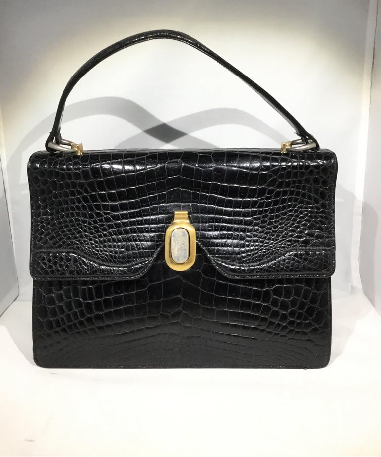 Rare Vintage Gucci handbag from the 1960’s beautifully crafted in Crocodile with a top handle (that has been restored), silver and gold tone metal clasp closure, one slip compartment and one spacious compartment with a zipper and slip pocket. Full