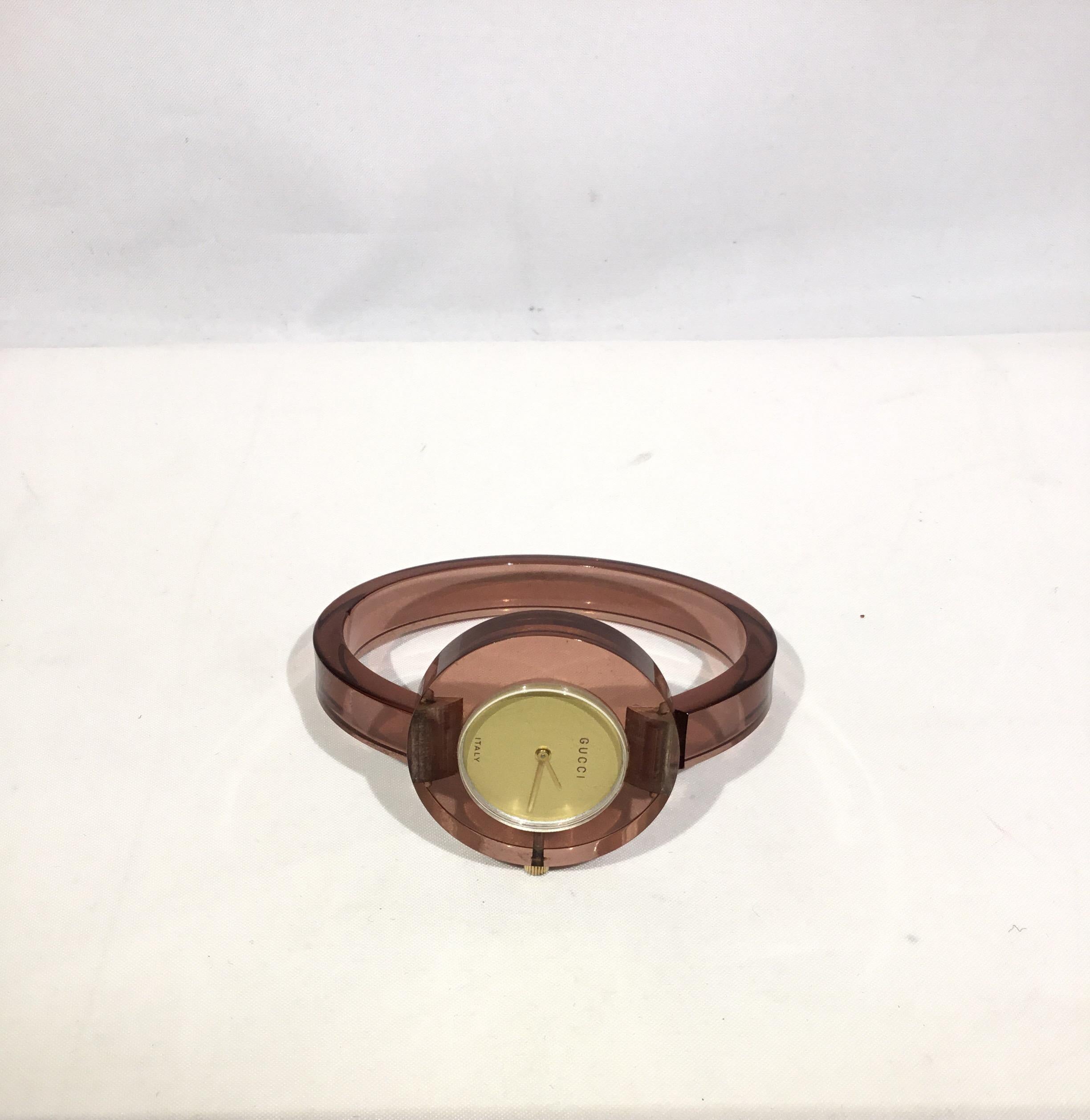 Vintage Gucci Lucite timepiece featured in a mauve color with a circular face. Made in Italy. Circumference 6.5 inches, 1cm wide band. Battery need replacement.