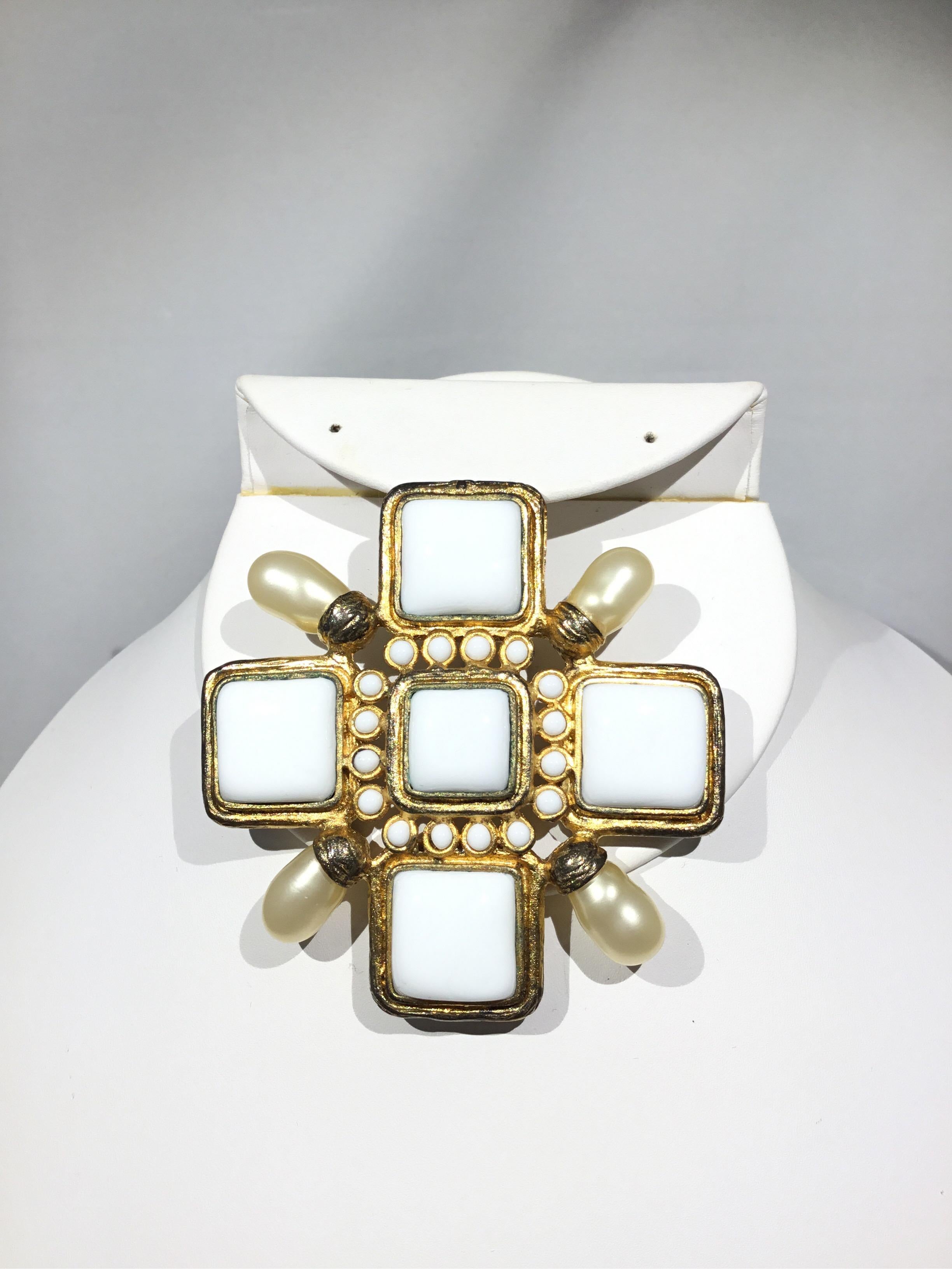 Chanel White Enamel and pearl brooch on a gold tone metal from Chanel’s 2001 Spring collection. Brooch also has a hook feature in which makes it wearable as a pendant for a necklace. Metal shows normal wears. 

Measurements: 3” x 3”,
Weight: 70.67